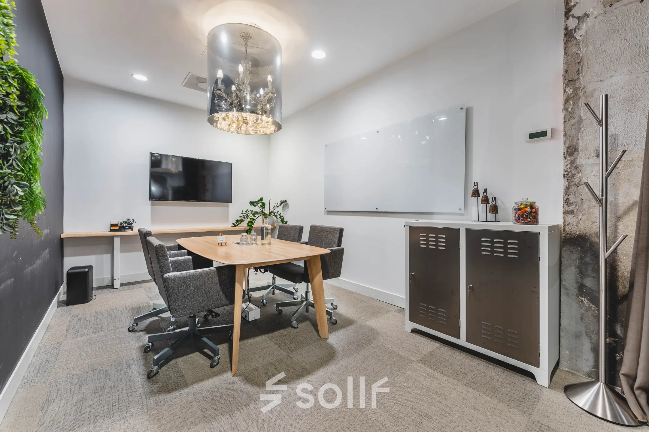 Bright conference room at Olympisch Stadion 24-28, Amsterdam Old South, featuring a table, chairs, and a wall-mounted TV, ideal for office space rental.