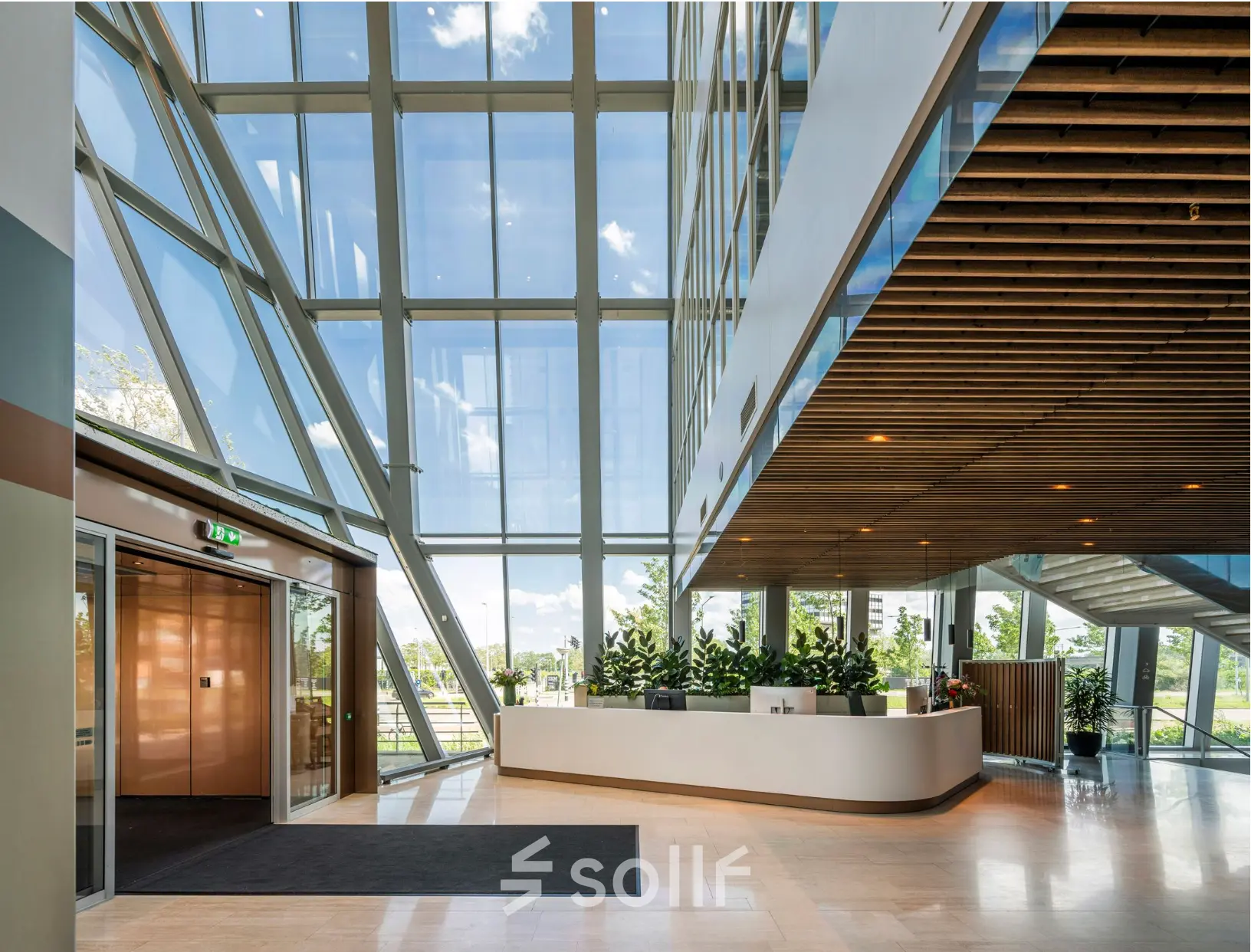 Spacious, bright office reception area with modern design and large windows at David Ricardostraat 1, ideal for office space rental in Amsterdam Riekerpolder.