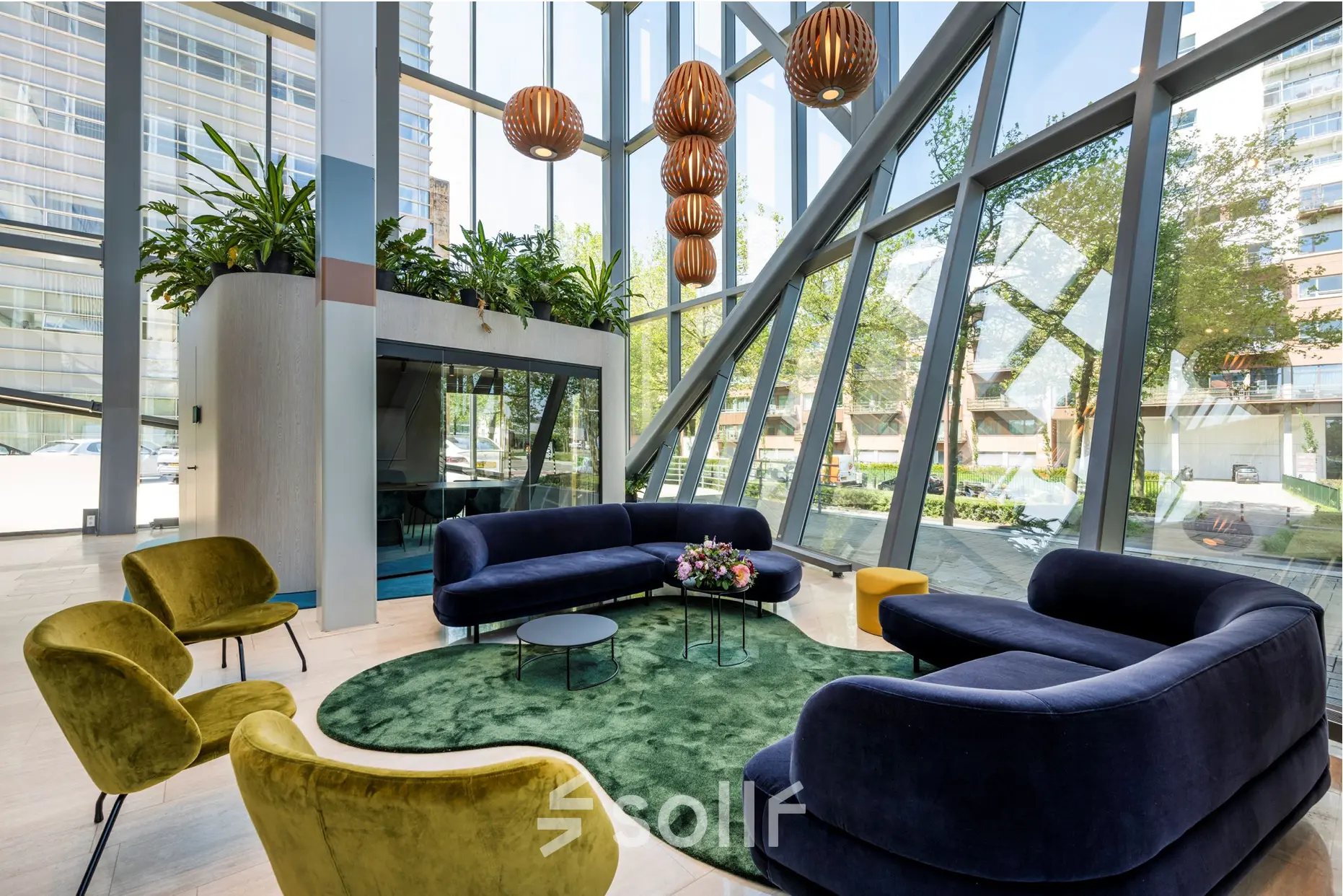 Bright office lounge area at David Ricardostraat 1 in Amsterdam Riekerpolder, featuring modern seating and large windows, ideal for office space rental.
