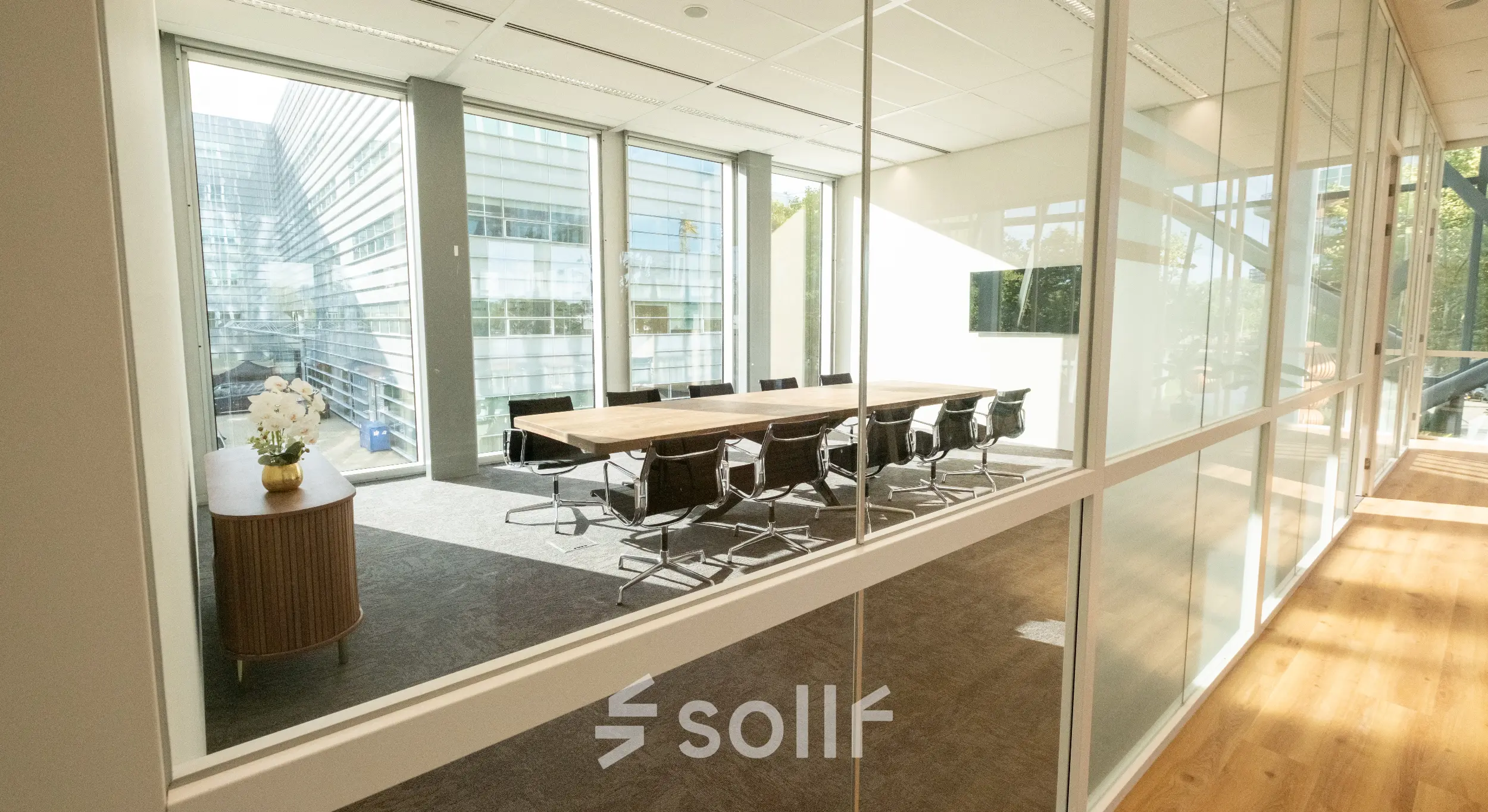 Bright conference room at David Ricardostraat 1 in Amsterdam Riekerpolder with large windows, modern table, and chairs, available for rent office space.