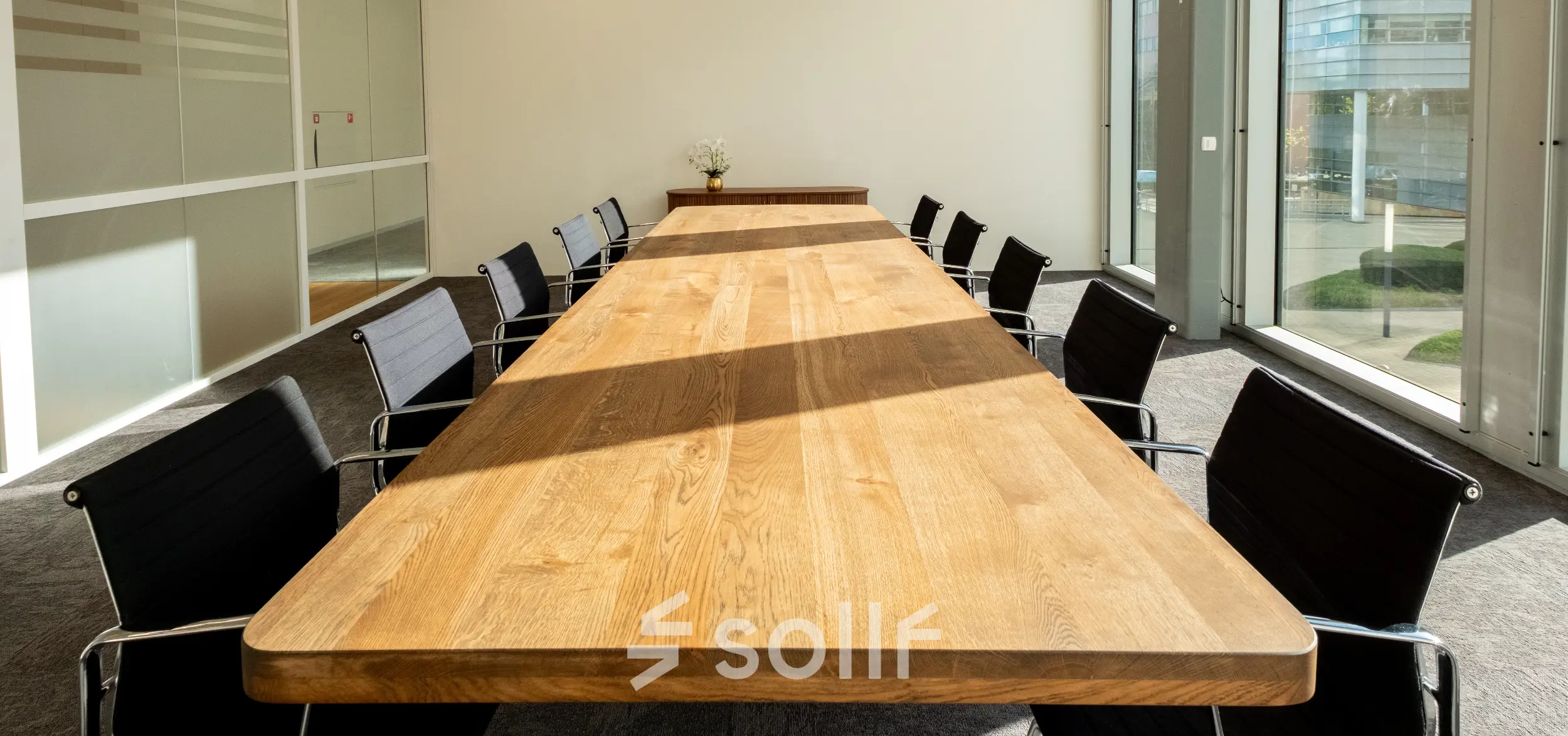 Spacious conference room with a long wooden table and modern chairs, ideal for office space rental in Amsterdam Riekerpolder.