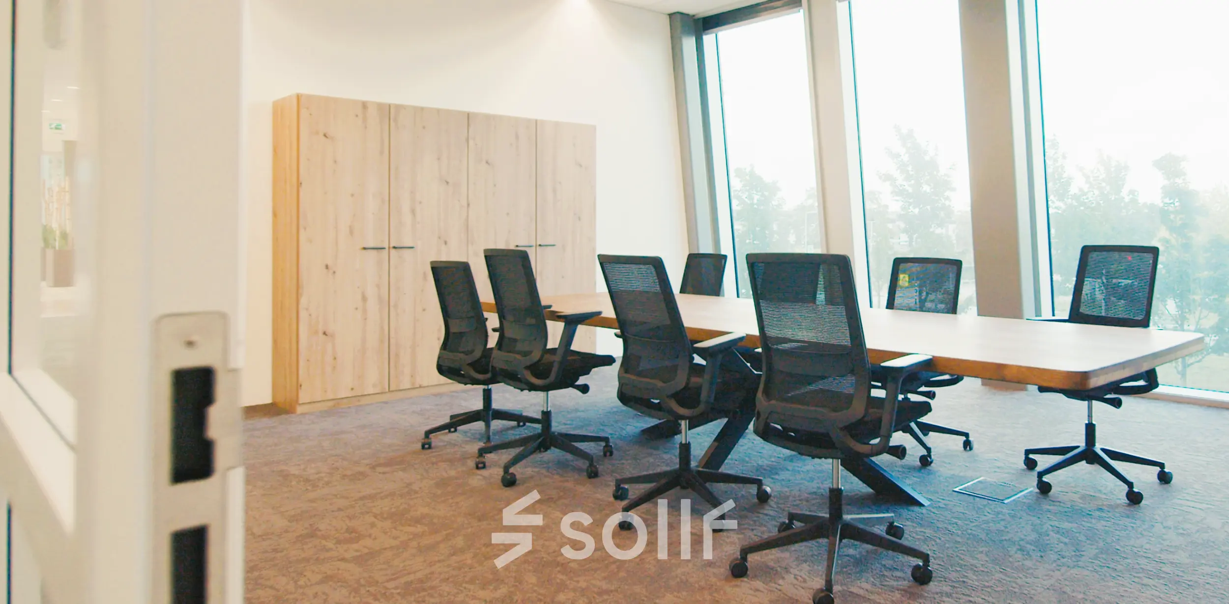 Modern workspace available for rent at David Ricardostraat 1, Amsterdam Riekerpolder, featuring a long table and ergonomic chairs, suitable for meetings and team collaborations.