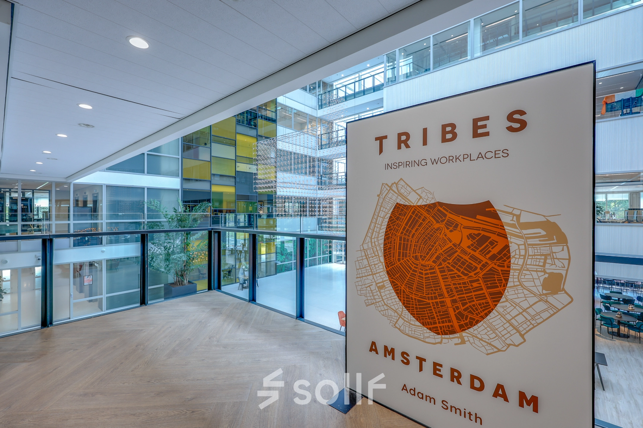 Modern interior with a large window showcasing an office building at Thomas R. Malthusstraat 1-3, a prime office space rental in Amsterdam Riekerpolder.