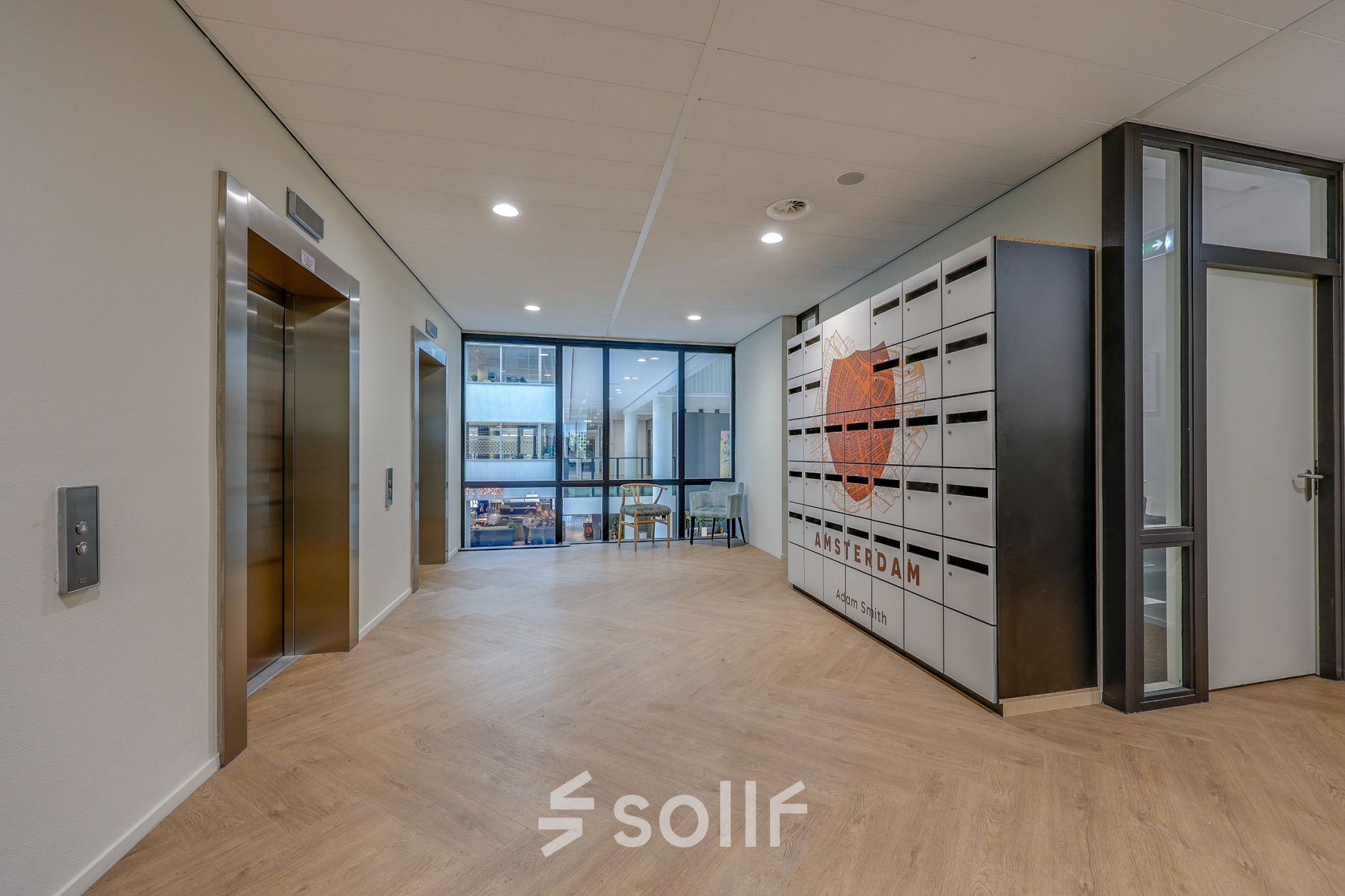 Office entrance in Amsterdam Riekerpolder with modern design, featuring an elevator and Amsterdam-themed decor, available for office space rental.