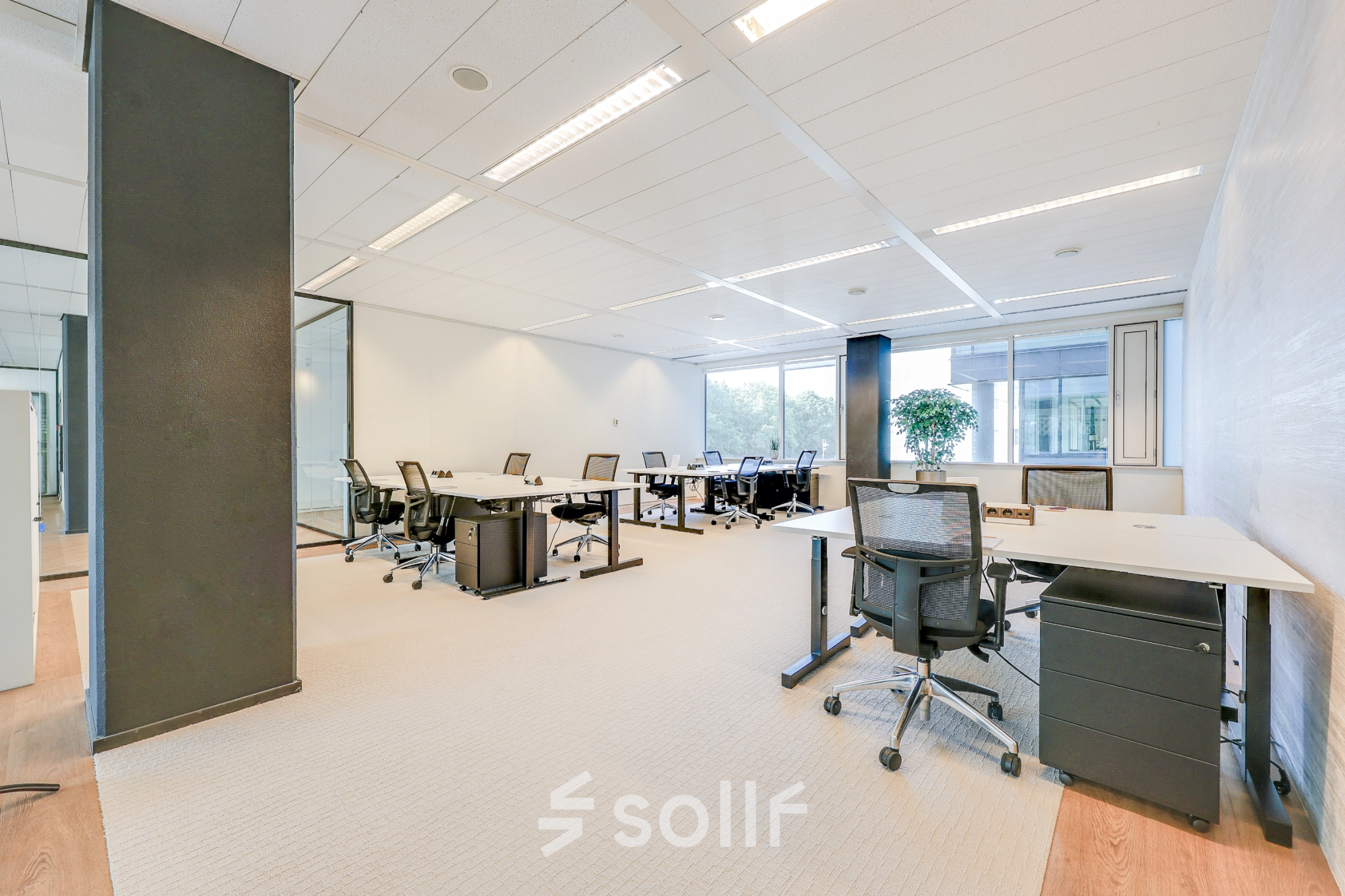 Bright office space with modern furniture and large windows at Thomas R. Malthusstraat 1-3, ideal for office space rental in Amsterdam Riekerpolder.