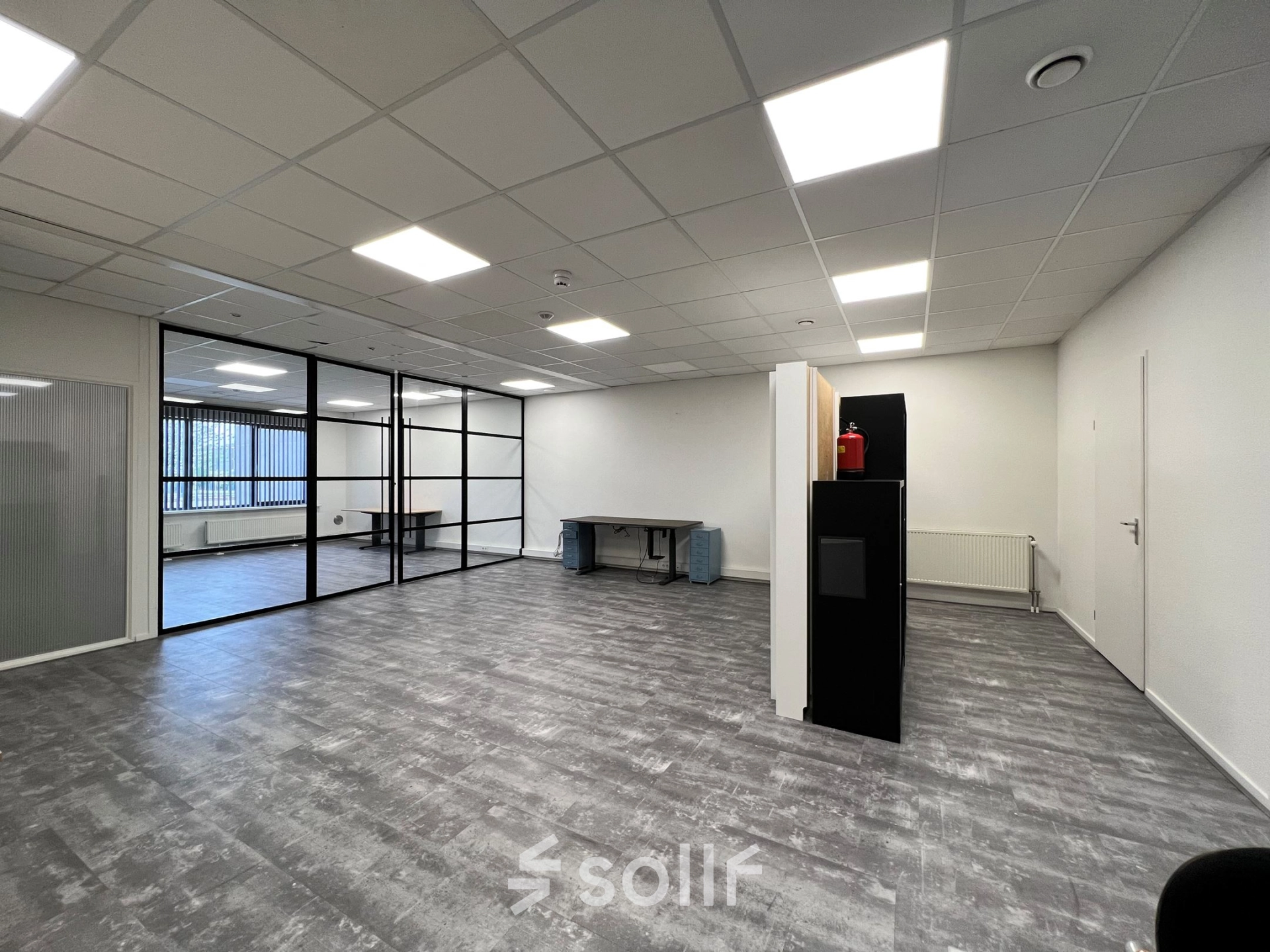 A well-lit office space with modern flooring and glass-partitioned area at Contactweg 131, Amsterdam Sloterdijk, available for rent.