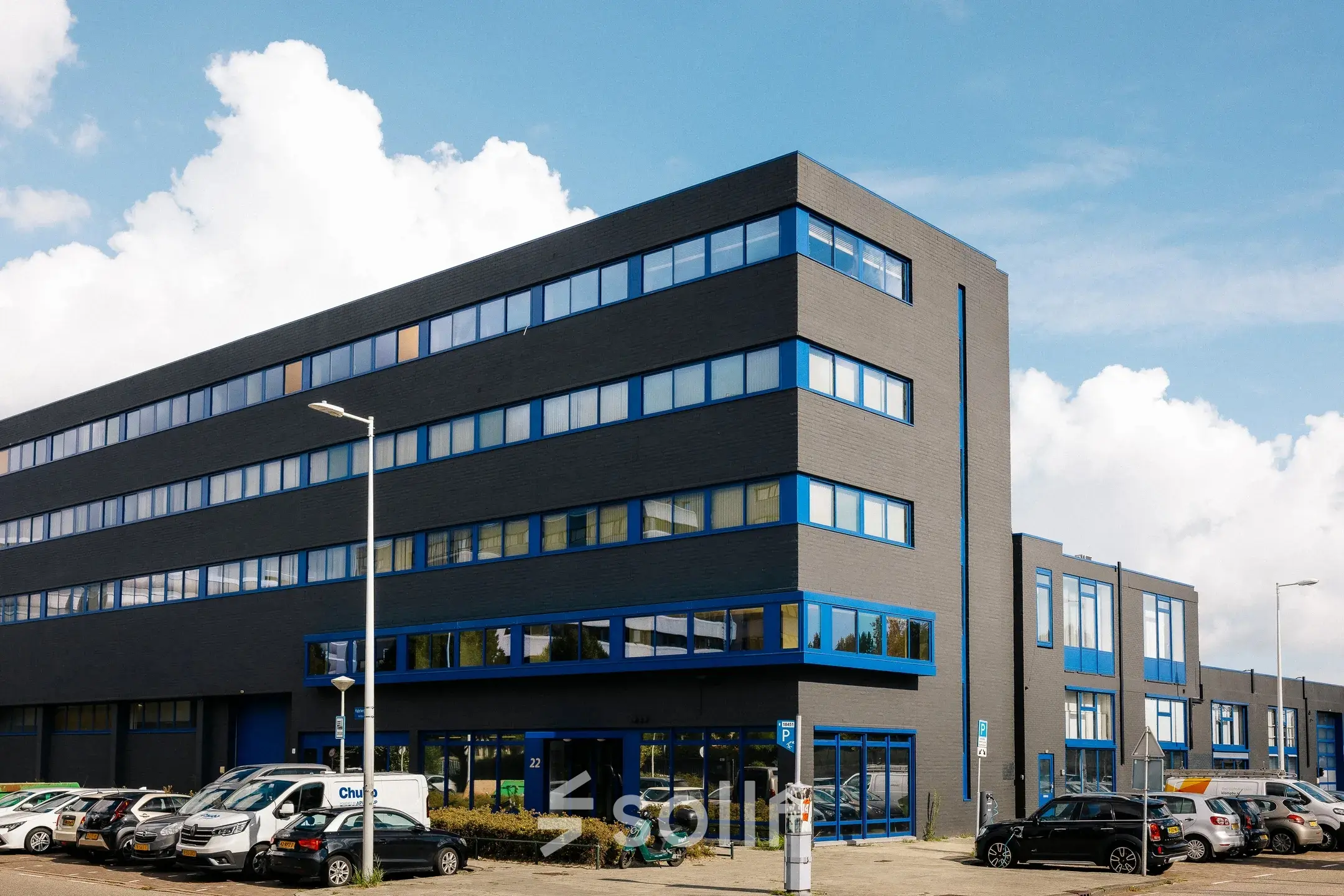 Exterior view of the office building at Kabelweg 24, Amsterdam Sloterdijk, ideal for office space rental with ample parking space.