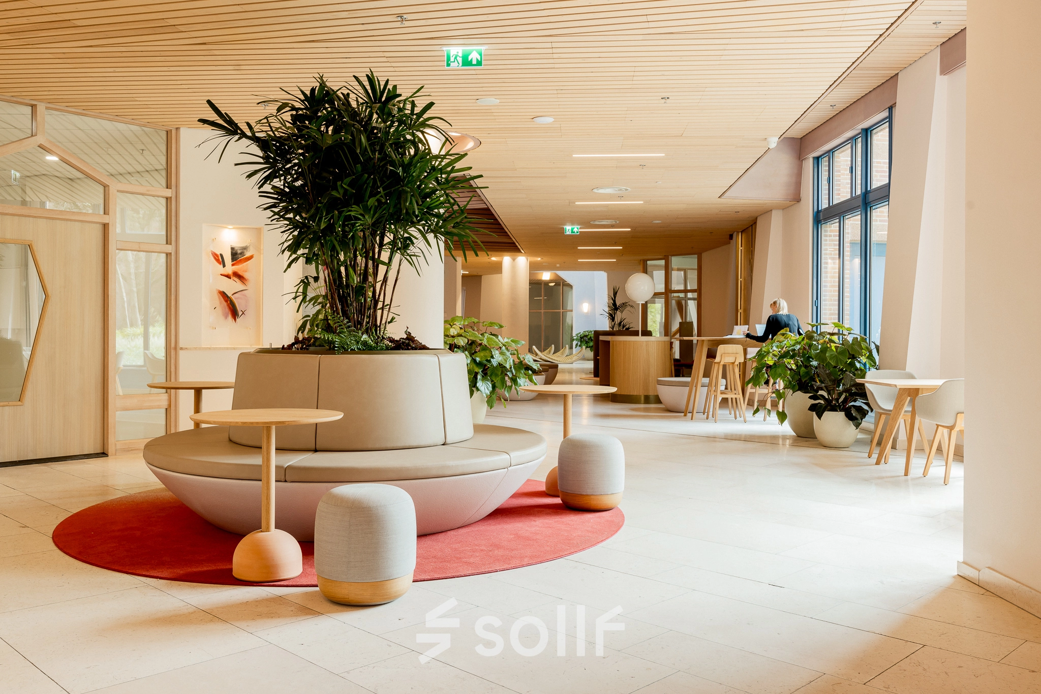 Modern office space in Amsterdam South East with stylish seating area and greenery, ideal for office space rental. Features natural light and vibrant design at Bijlmerplein 888.