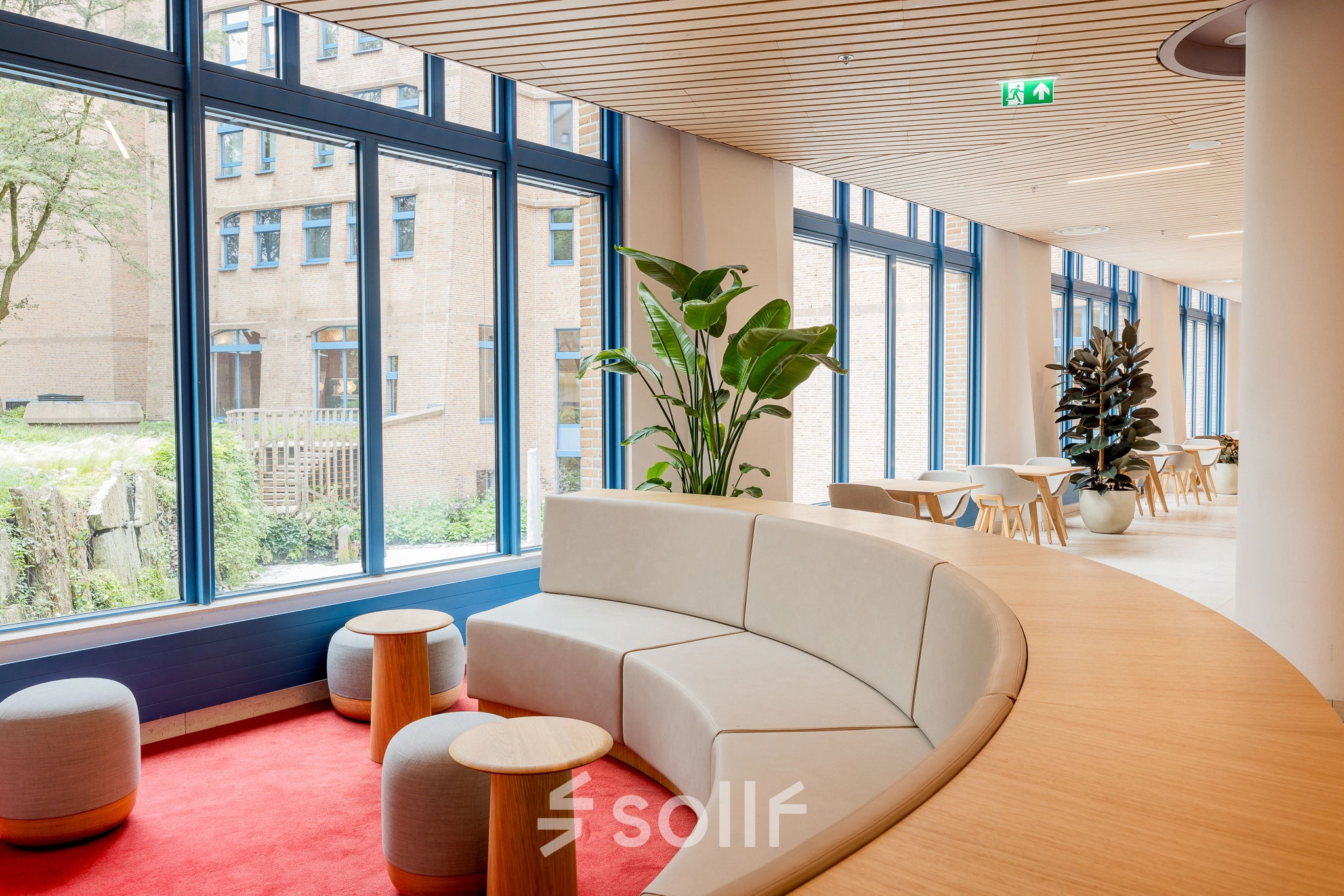 Spacious, modern office lounge with stylish seating and large windows at Bijlmerplein 888, Amsterdam South East, ideal for office space rental.