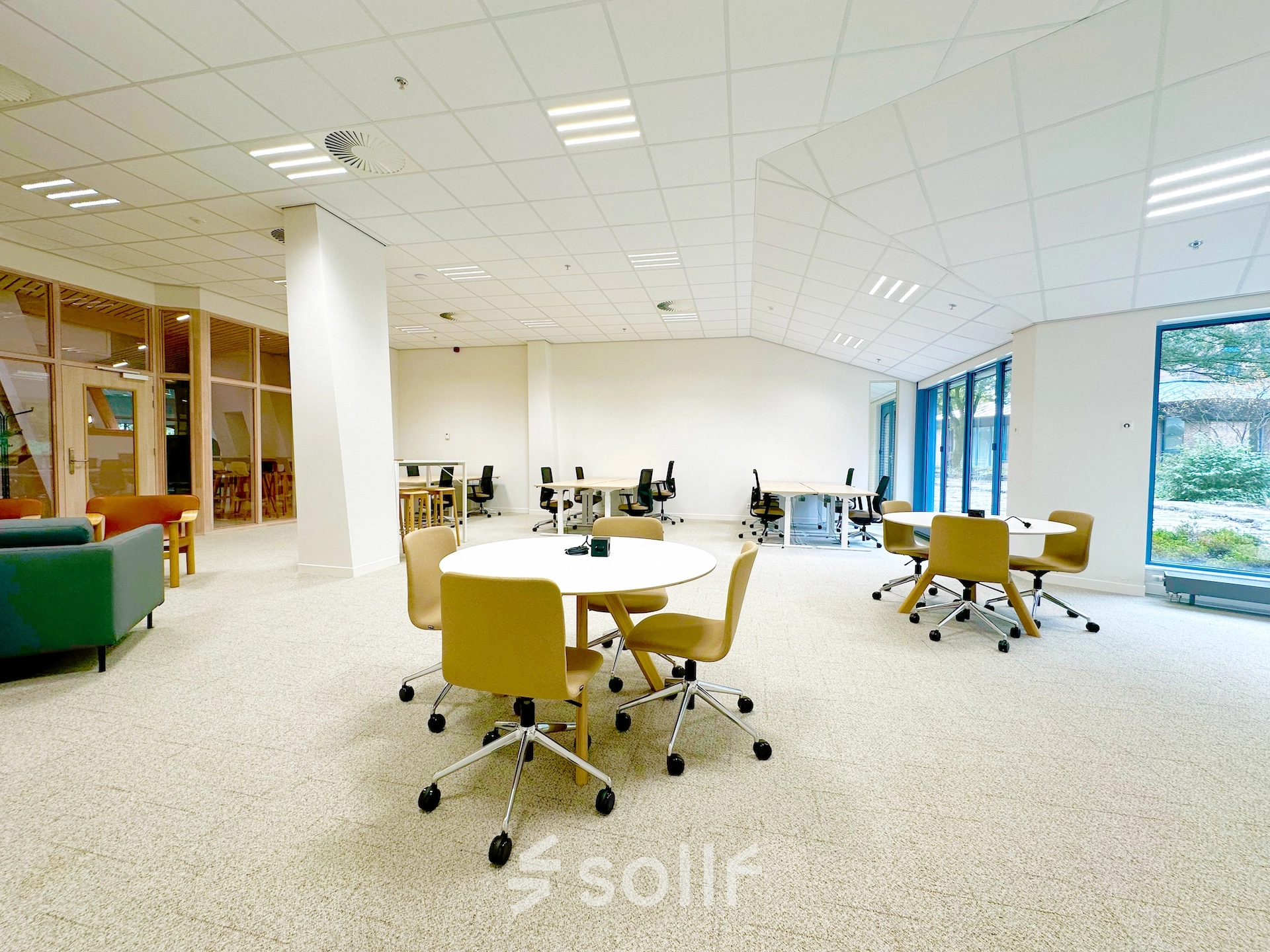 Modern office space for rent at Bijlmerplein 888, Amsterdam South East, featuring spacious workspaces with chairs, tables, and large windows offering natural light.