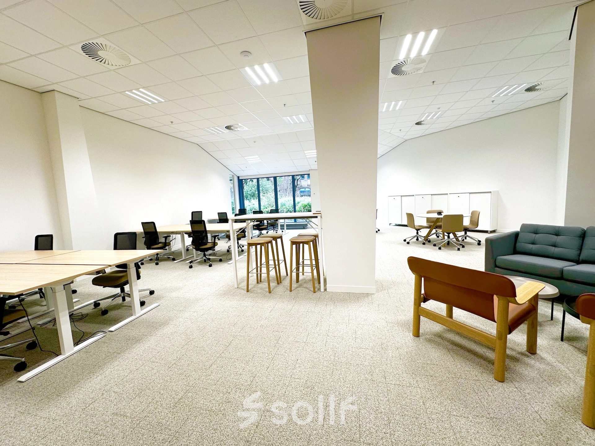 Spacious, well-lit office for rent at Bijlmerplein 888 in Amsterdam South East, featuring modern furnishings and an open work area with desks, chairs, and seating options.