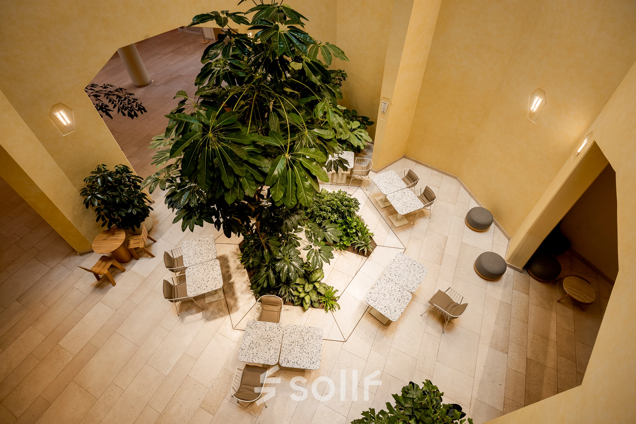 Bright office space rental at Bijlmerplein 888, Amsterdam South East, featuring modern seating and lush greenery.