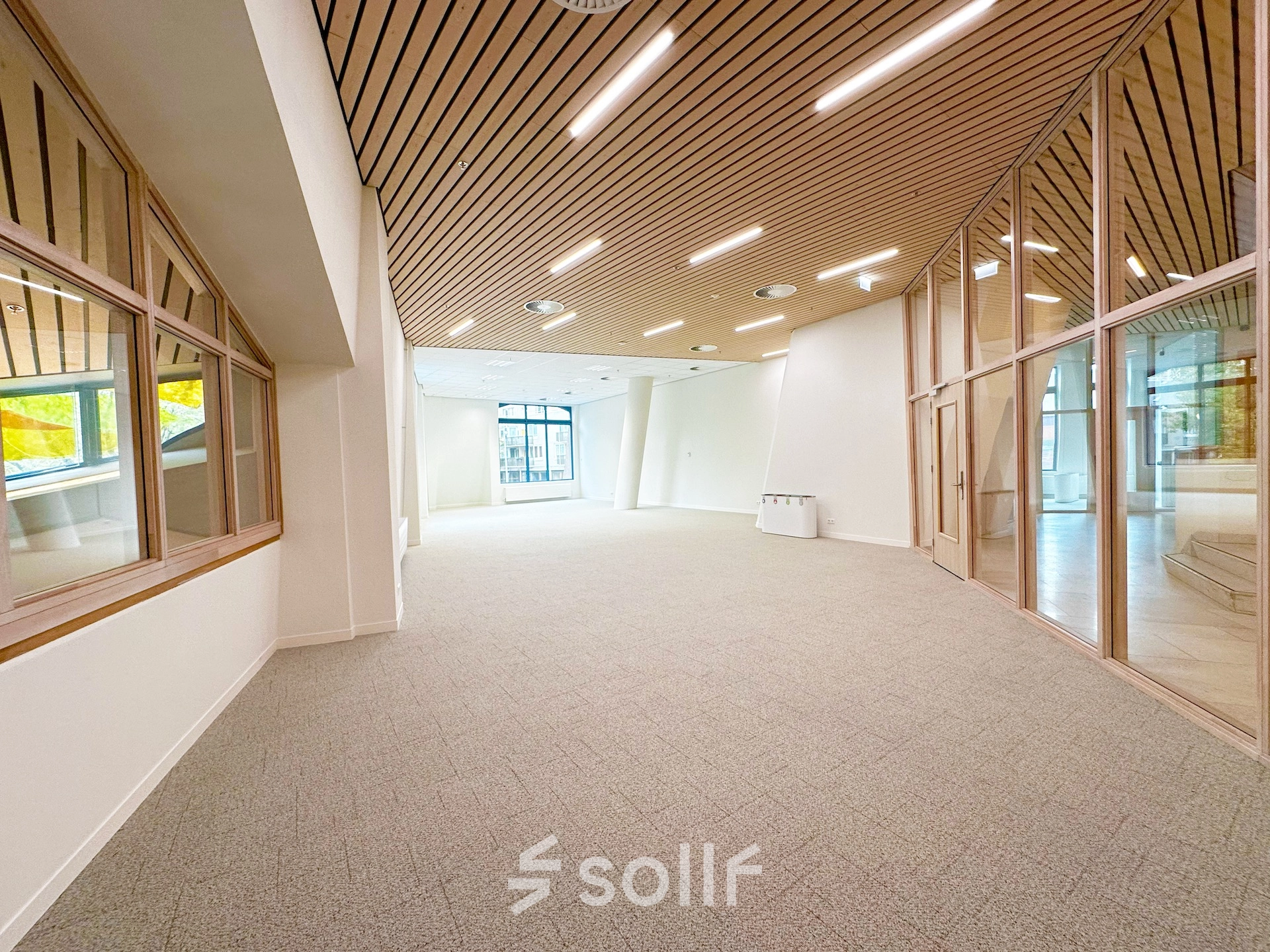 Spacious and modern office space at Bijlmerplein 888 in Amsterdam South East, featuring large windows and wooden ceiling accents, ideal for rent office space.
