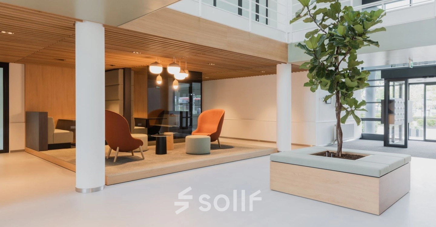 Spacious and modern office lounge in Amsterdam South East with stylish seating and natural lighting, ideal for office space rental.