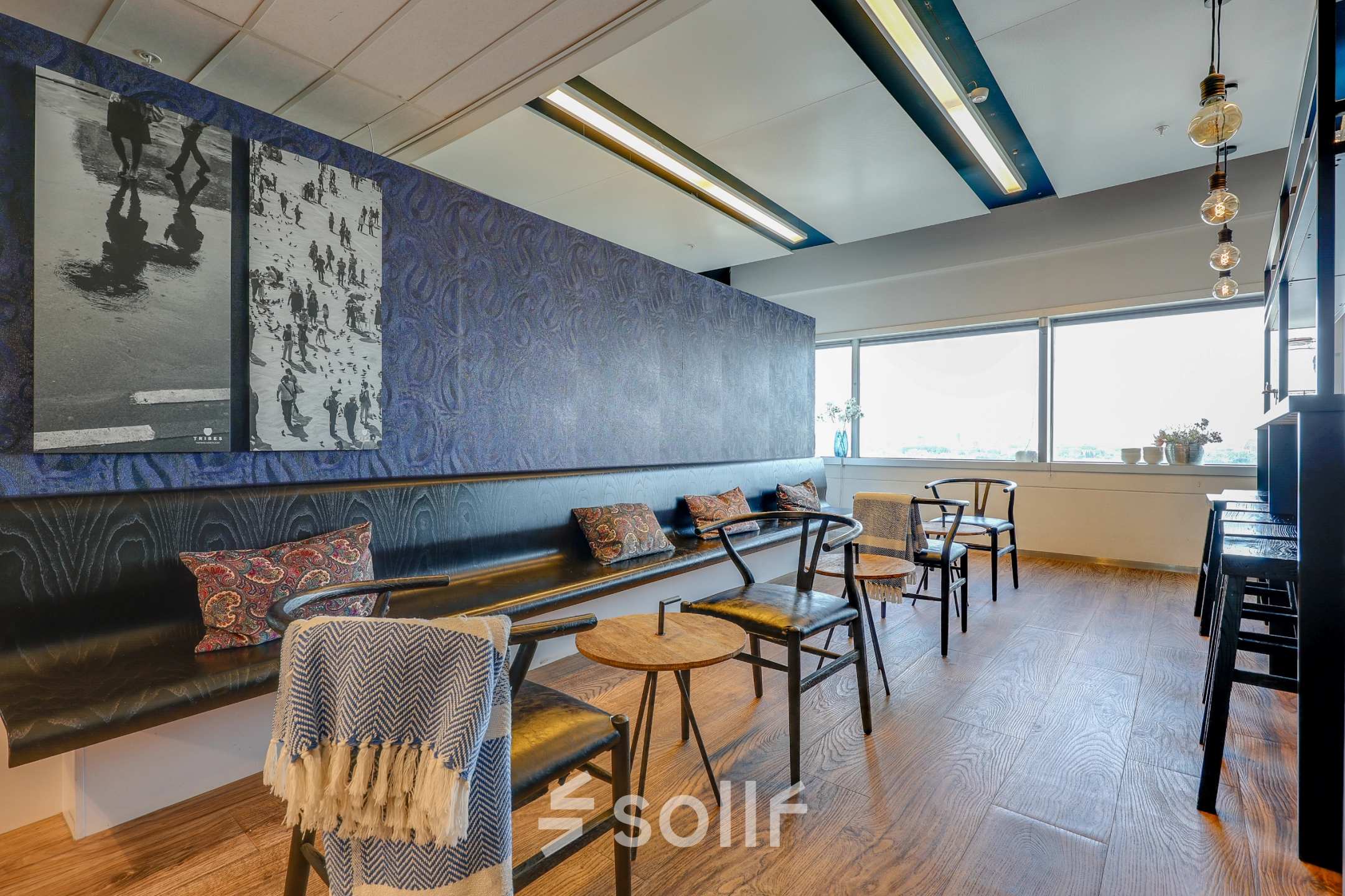 Bright office space in Amsterdam South East with seating and decorative wall art, available for office space rental.
