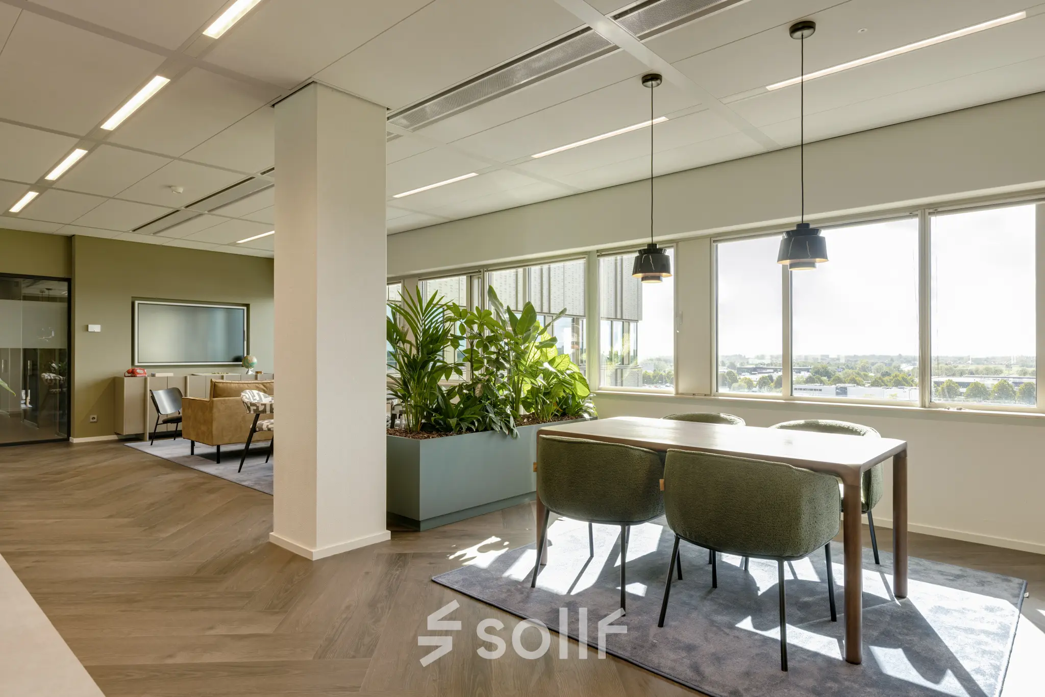 Bright office space with a mix of workstations and a seating area, located at Herikerbergweg 288, Amsterdam South East, ideal for office space rental.