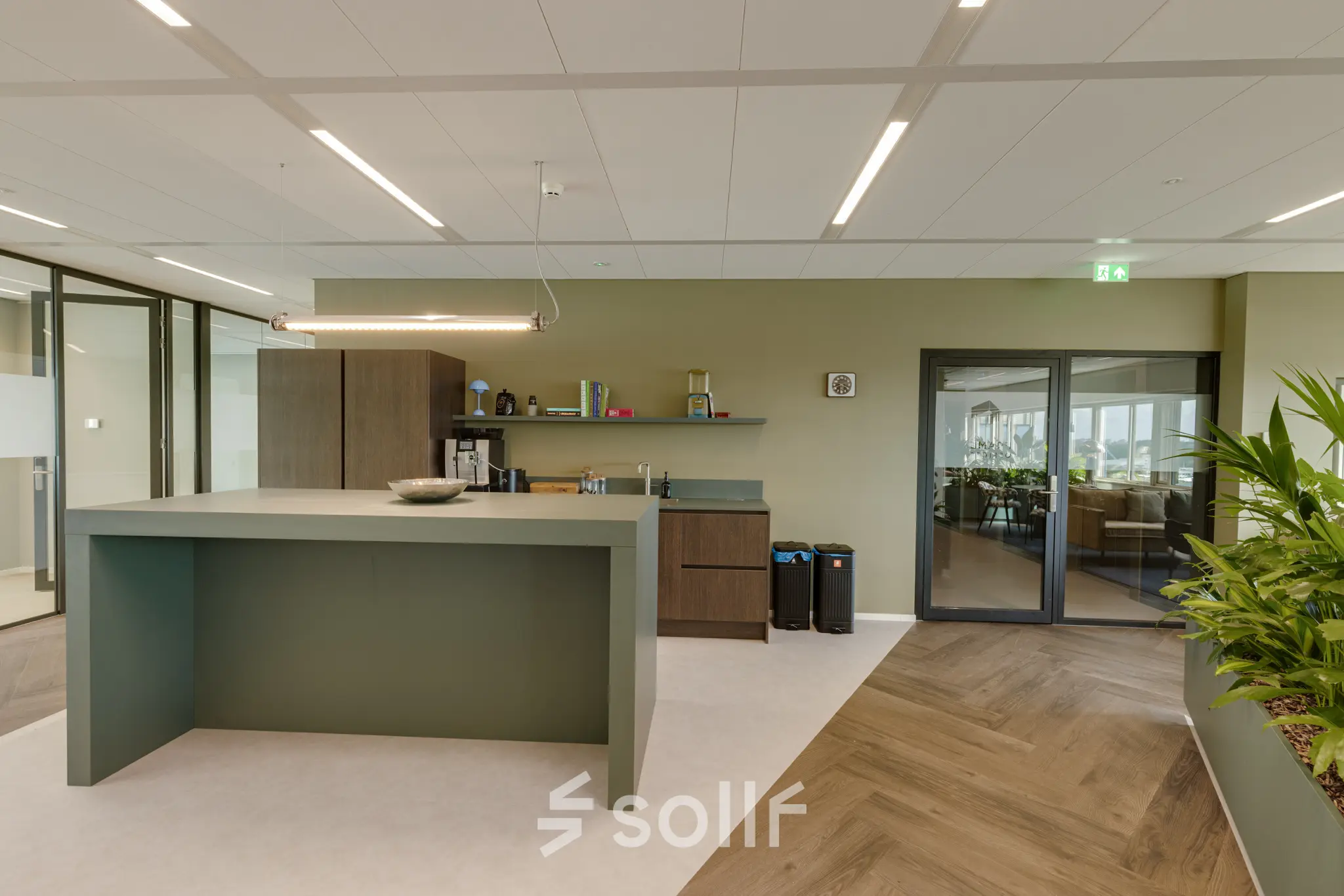 Modern office space rental with a sleek pantry area and a view of glass-walled rooms at Herikerbergweg 288, Amsterdam South East.