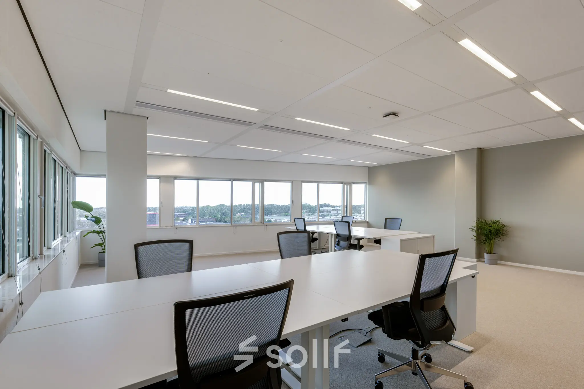 Spacious office to rent at Herikerbergweg 288, Amsterdam South East, featuring modern desks and chairs with large windows allowing ample natural light.