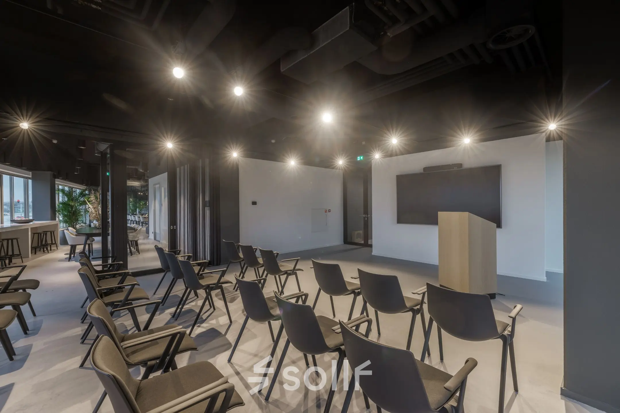 Conference room at Herikerbergweg 290 in Amsterdam South East featuring rows of chairs and a podium, ideal for office space rental.