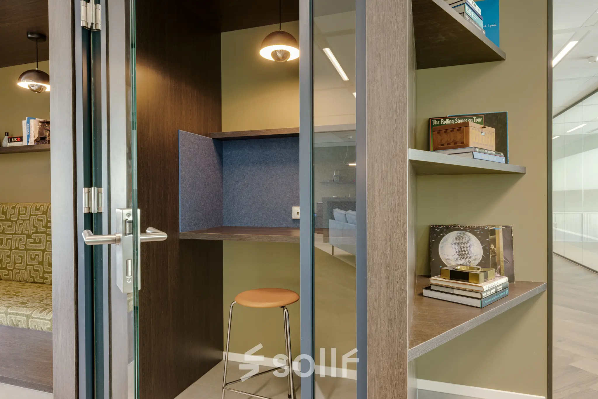 Modern furnished office space in Amsterdam South East with bookshelves and a sleek seating area, available for rent.