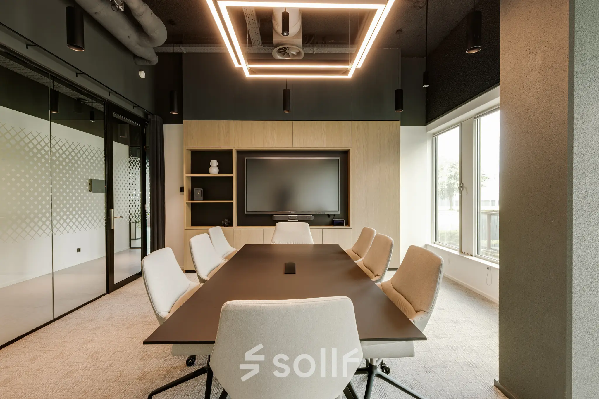 Modern conference room in Amsterdam South East with sleek lighting and a large table, ideal for office space rental.
