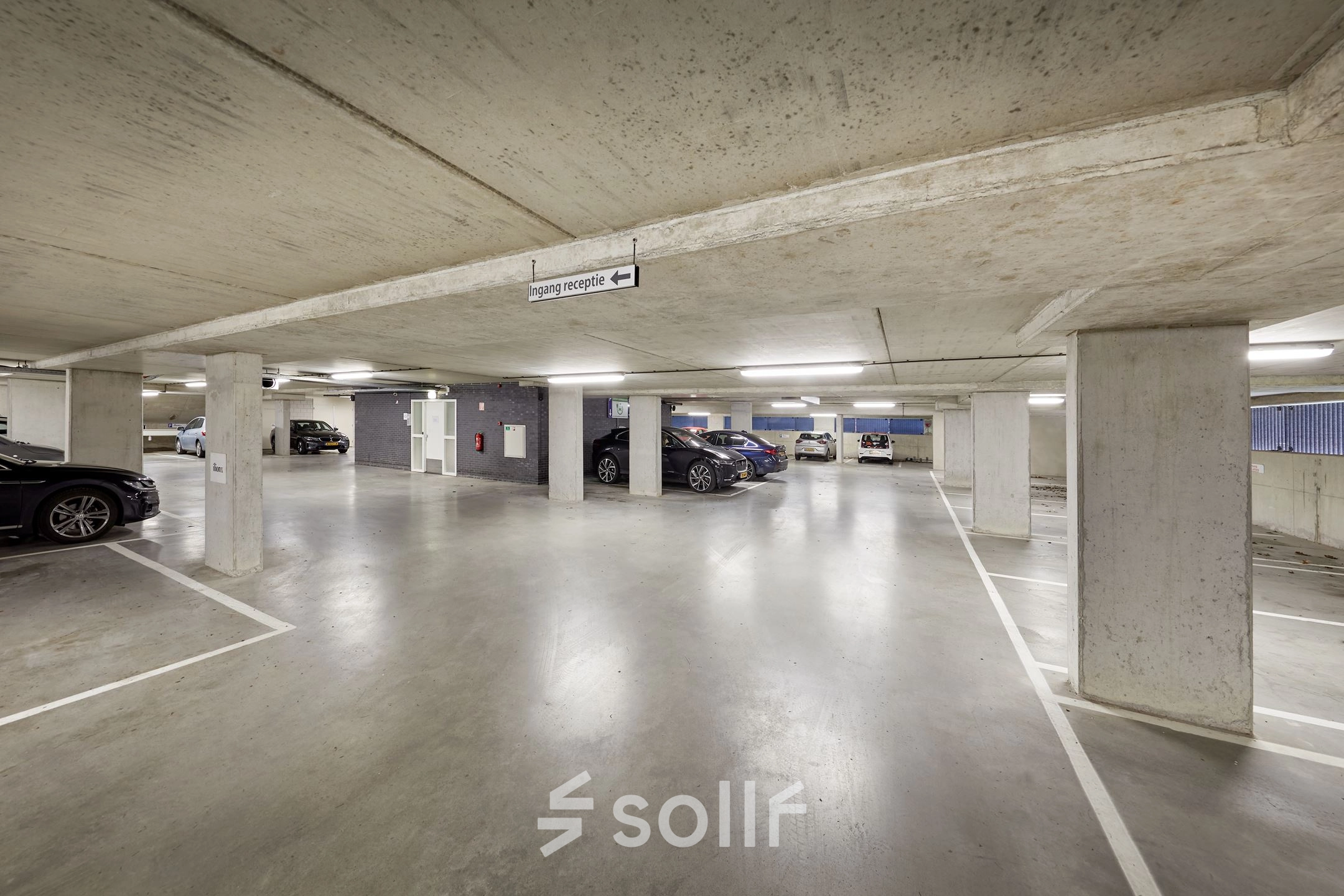 Spacious parking area at Hogehilweg 24, perfect for those seeking secure office space rental in Amsterdam South East. Multiple cars are parked neatly, offering ample space for vehicle accommodation.