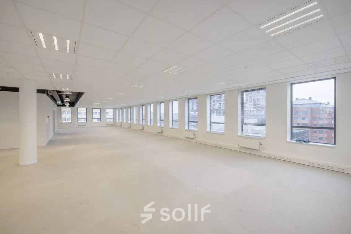 An unfurnished office space for rent at Hogehilweg 24, Amsterdam South East, featuring large windows and ample lighting, ideal for customizing to your business needs.