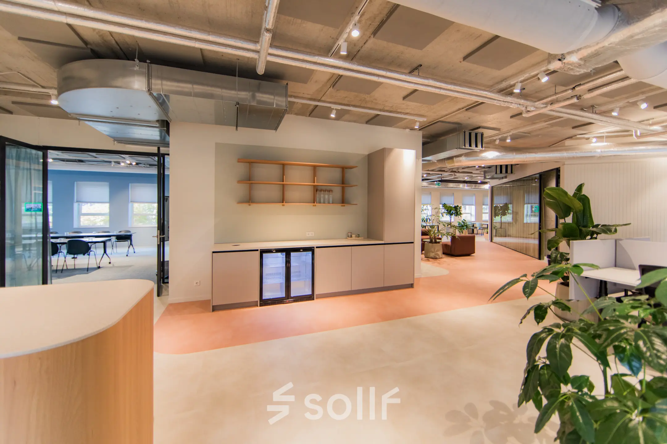 Modern office space at Hullenbergweg 109-135, Amsterdam South East, featuring stylish interiors with light flooring, a kitchenette, and contemporary furnishings, ideal for office space rental.