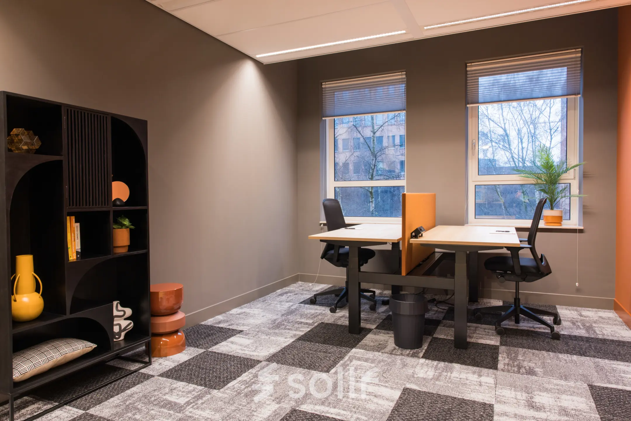 Bright office space with two desks and chairs, natural light from large windows, and contemporary decor at Hullenbergweg 109-135 in Amsterdam South East. Ideal for office space rental.