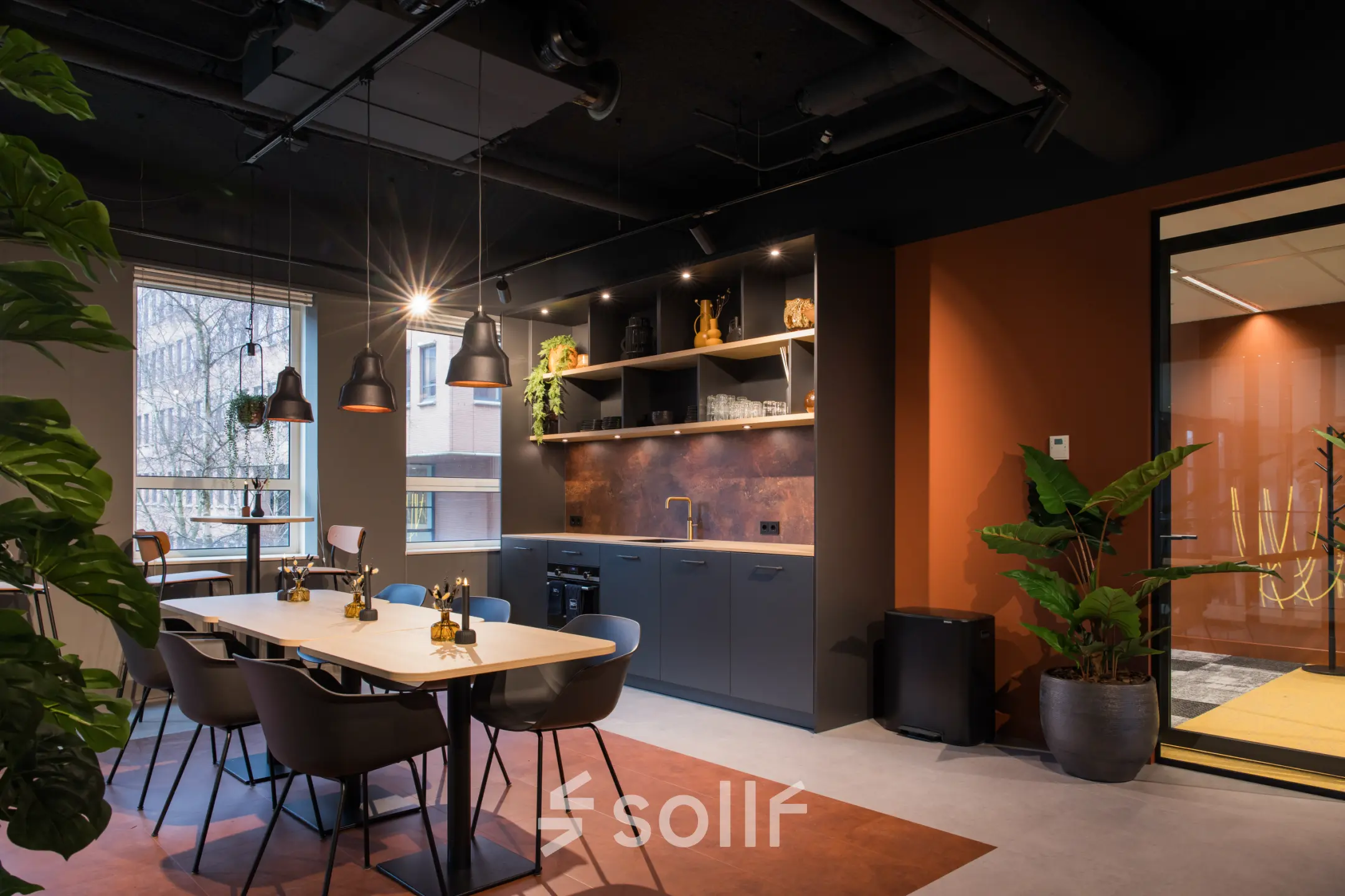 Modern office space in Amsterdam South East at Hullenbergweg 109-135, featuring a stylish furnished interior with a communal workspace and kitchenette for office space rental activities.