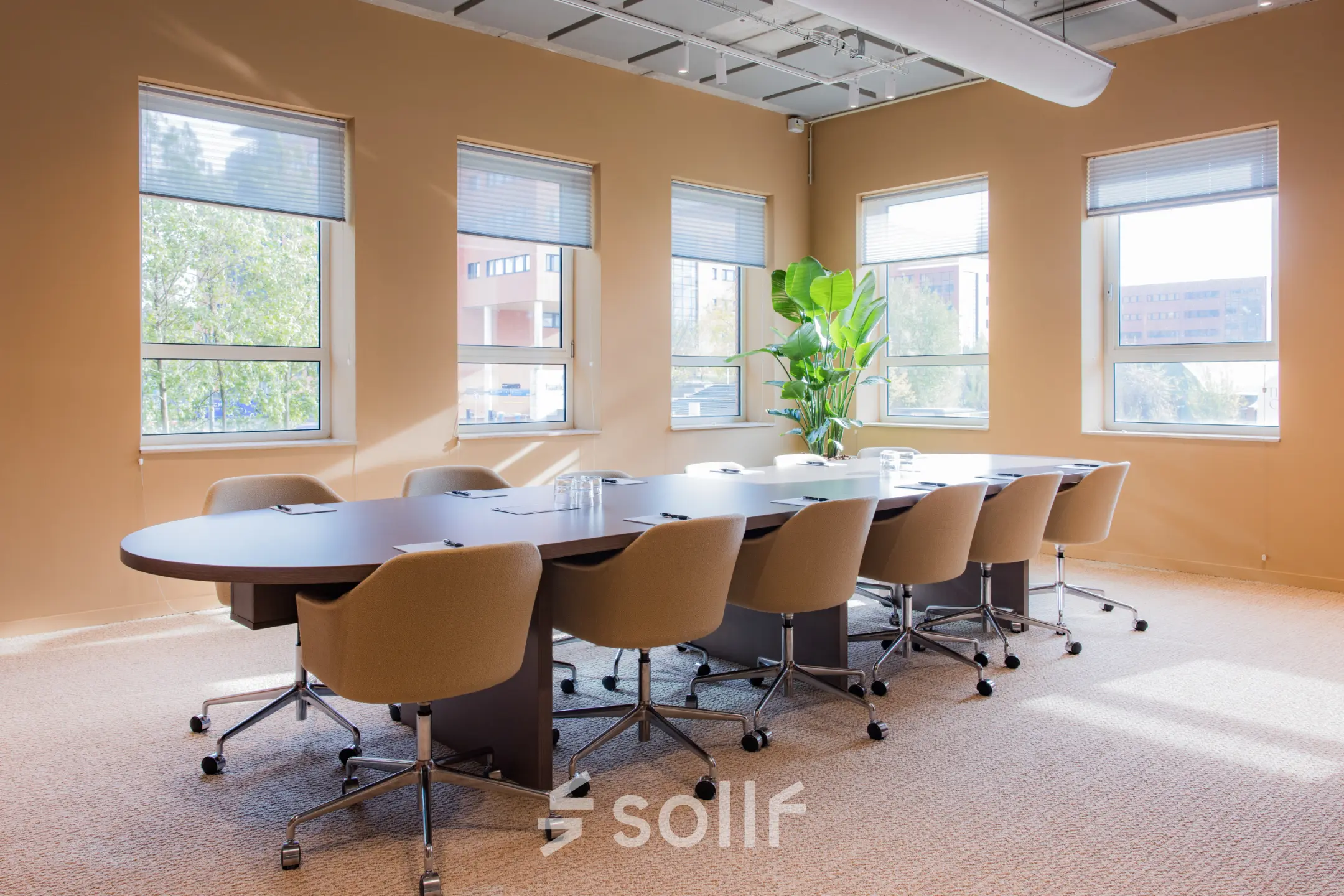 Bright office space with large windows and a meeting table in Amsterdam South East, ideal for rent office space seekers wanting a productive environment.