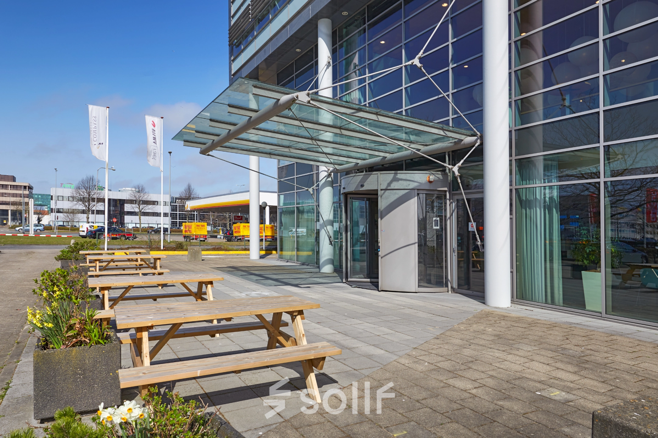 Exterior view of modern office building at Laarderhoogtweg with outdoor seating in Amsterdam South East, ideal for office space rental.