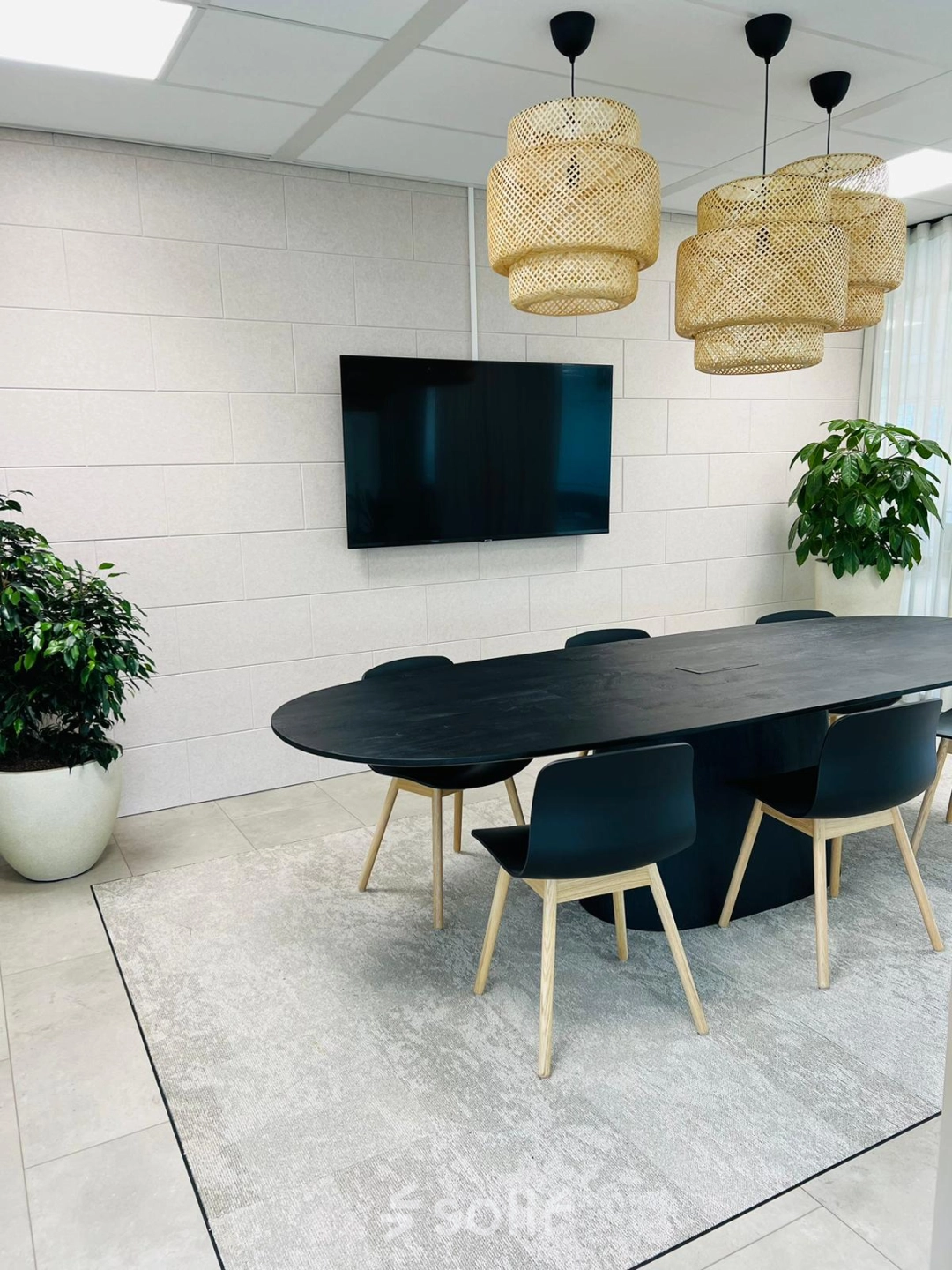 Modern office space at Laarderhoogtweg 7-19, Amsterdam South East featuring a sleek conference room with a central table, chairs, and a large wall-mounted screen, ideal for meetings.