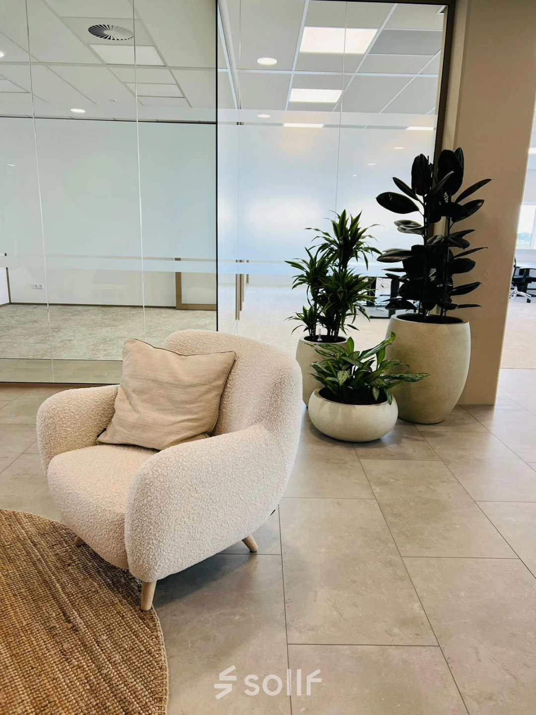 Modern office space in Amsterdam South East featuring cozy seating, plants, and glass-walled rooms, perfect for office space rental.