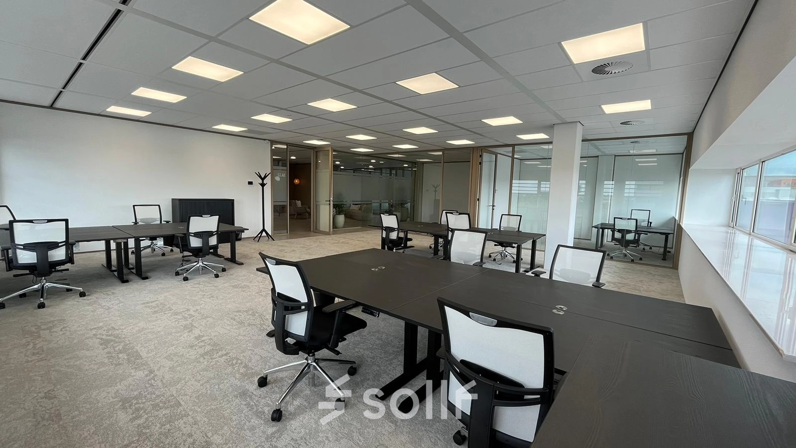 Interior view shows a furnished workspace at Laarderhoogtweg 7-19 in Amsterdam South East, ideal for office space rental with multiple desks and chairs under bright lighting.