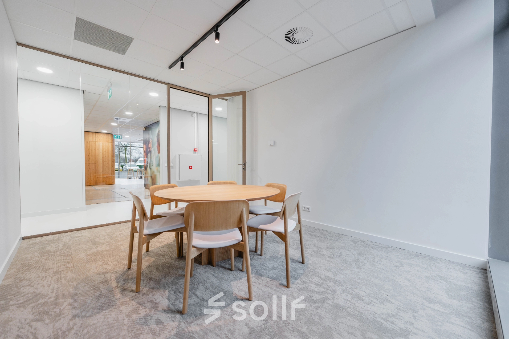A furnished meeting area in the office space at Laarderhoogtweg 7-19, Amsterdam South East, ideal for office space rental with a round wooden table and chairs.