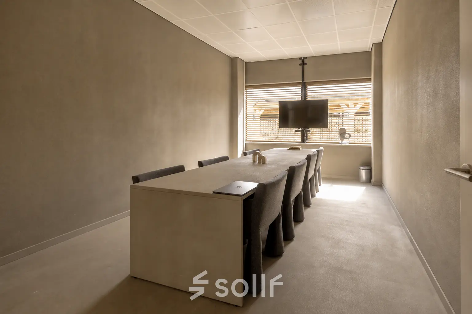 A conference room at Luttenbergweg 8, Amsterdam South East, featuring a large table, several chairs, and a mounted screen, ideal for office space rental.