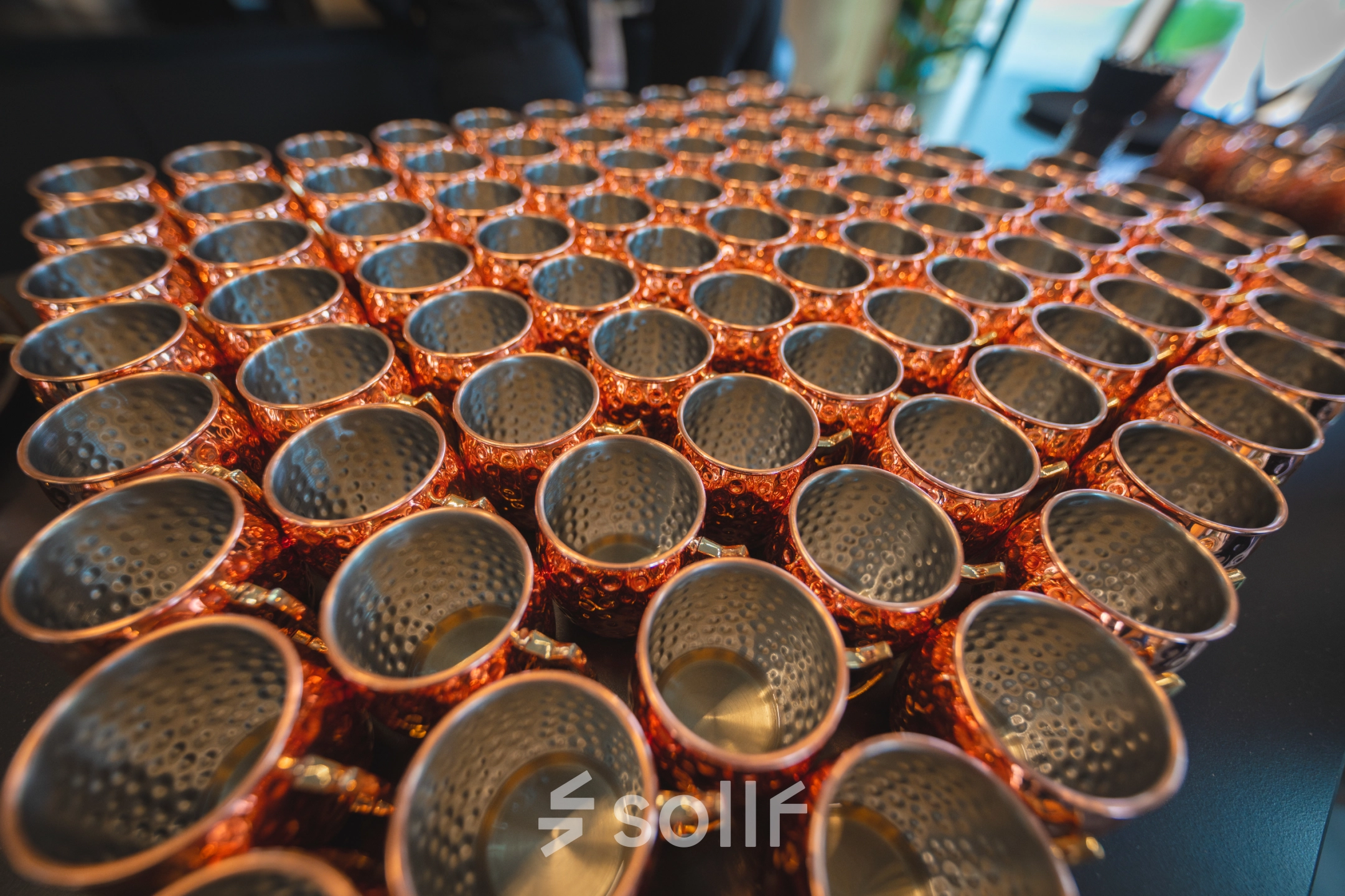 Copper cups are neatly arranged in rows on a table at Luttenbergweg 8, Amsterdam South East, showcasing a unique feature of the office space rental.