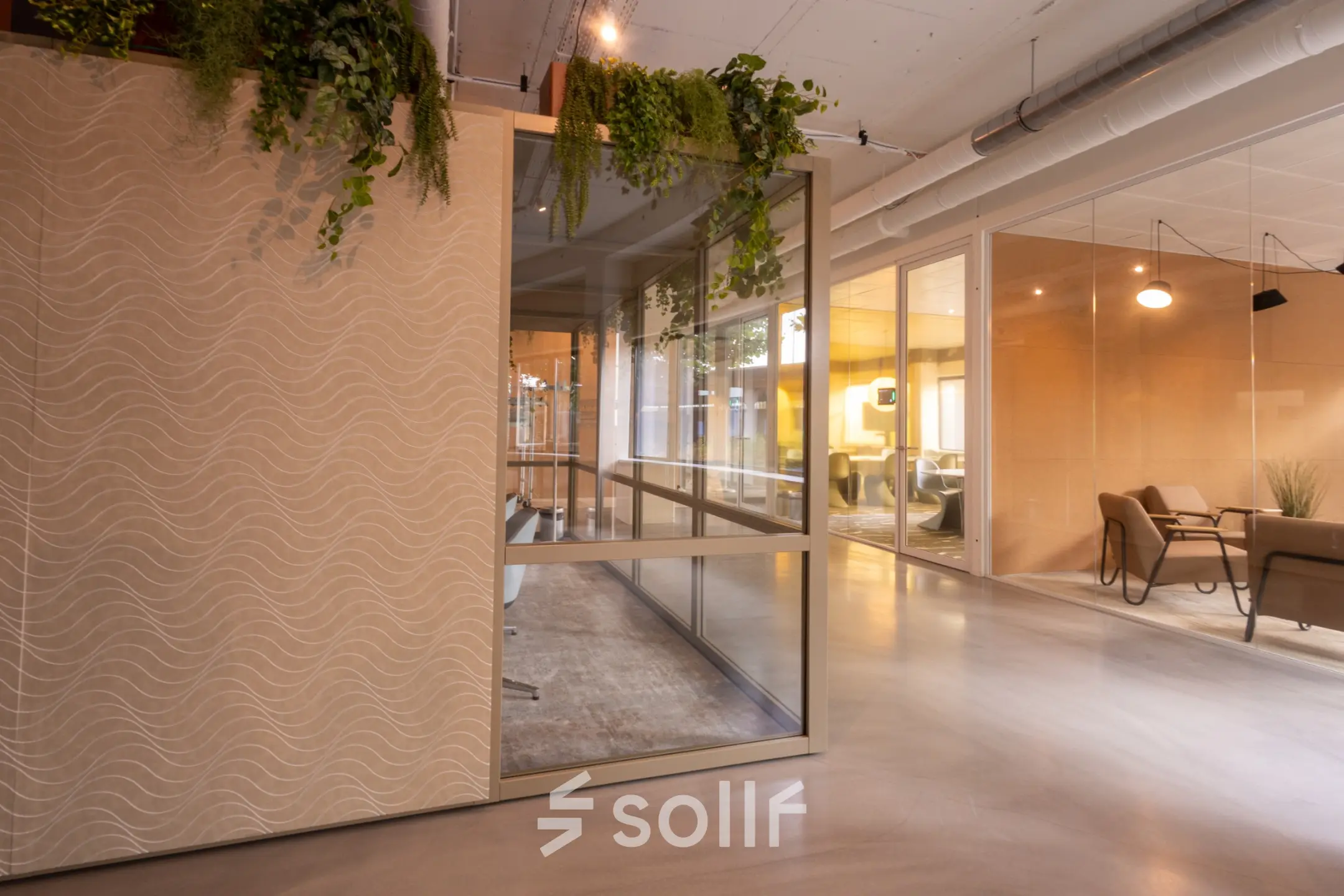 Modern office space at Luttenbergweg 8, Amsterdam South East, featuring open rooms with glass partitions and plants, ideal for office space rental.