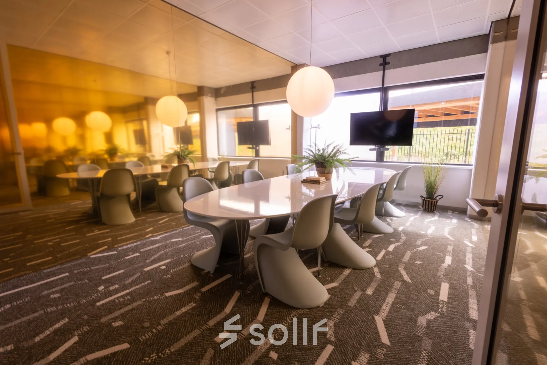 Bright conference room with modern chairs and large table, featuring natural light and a TV screen. Perfect for office space rental at Luttenbergweg 8, Amsterdam South East.