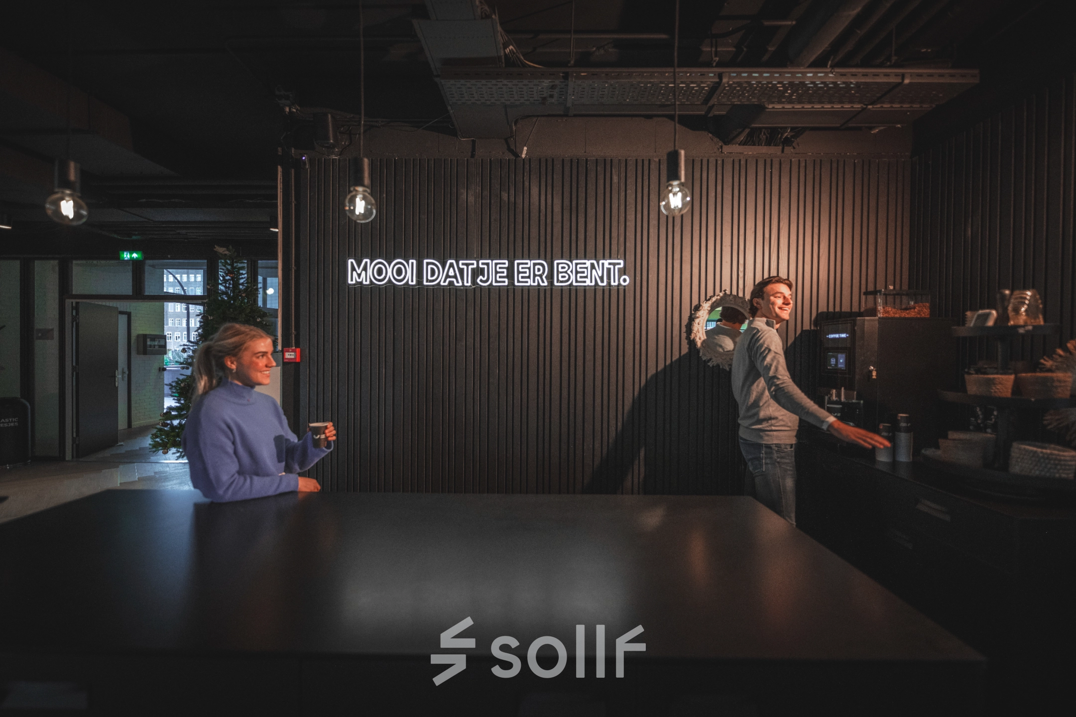 Two people enjoying a coffee break in a stylish, modern kitchen space at an office to rent in Amsterdam South East.