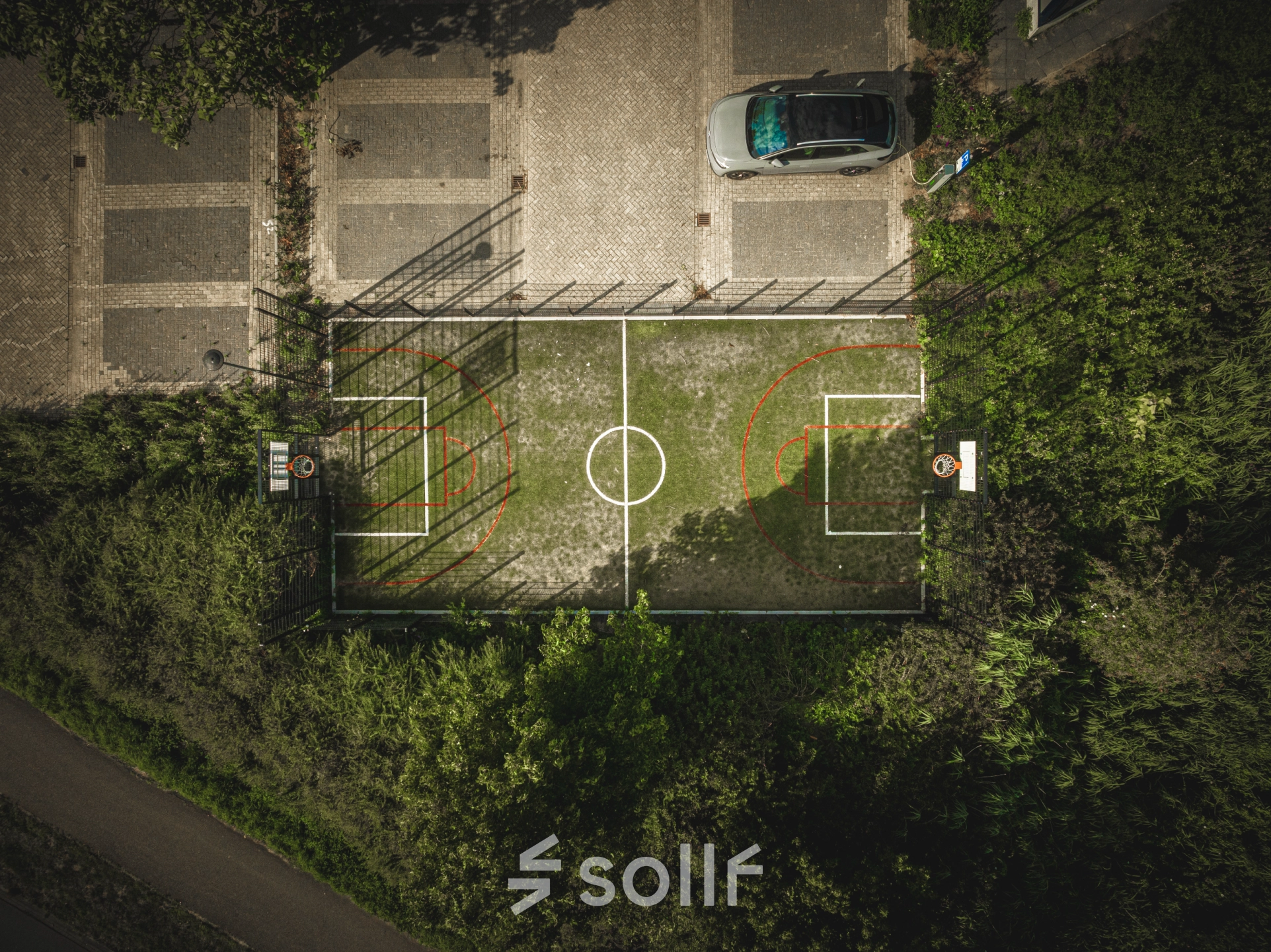 Aerial view of an outdoor sports court near the parking area at Luttenbergweg 8 in Amsterdam South East, highlighting the proximity to rent office space.