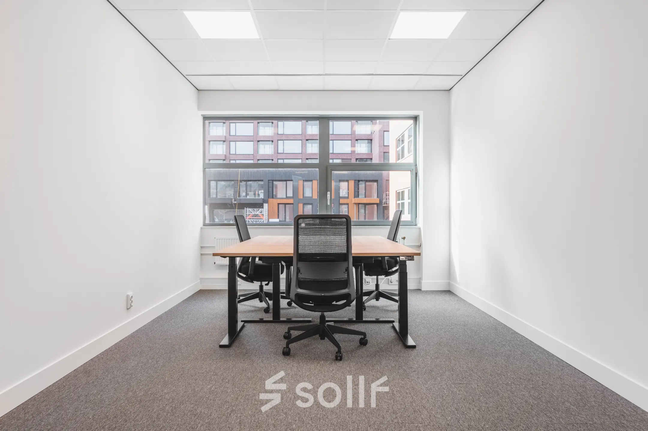 Bright office space rental at Paasheuvelweg 20, Amsterdam South East, featuring a large window and modern furnishings, perfect for collaborative work.