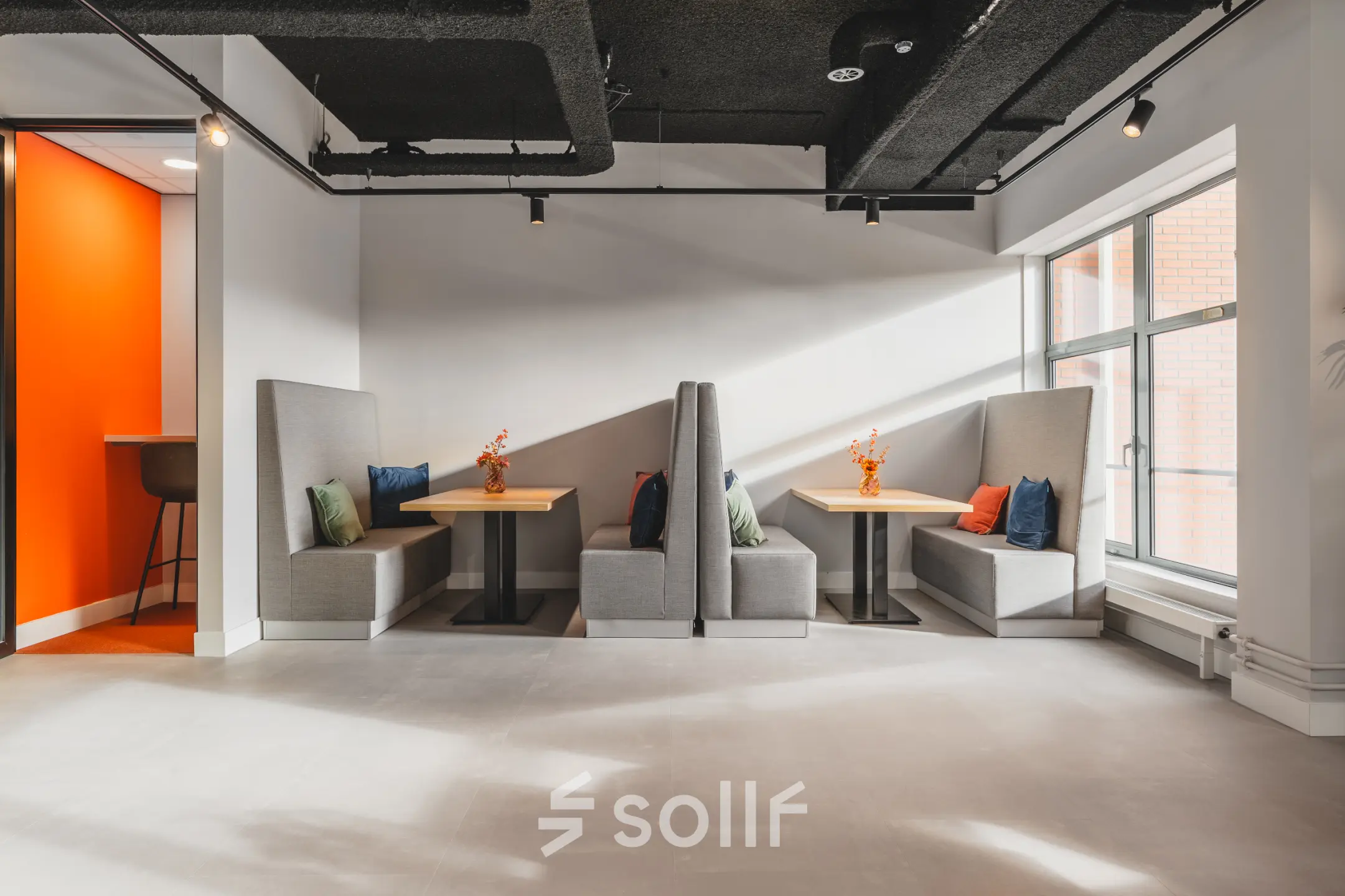 Modern office space rental at Paasheuvelweg 20 in Amsterdam South East, featuring cozy booth seating with cushions and a bright, inviting atmosphere.