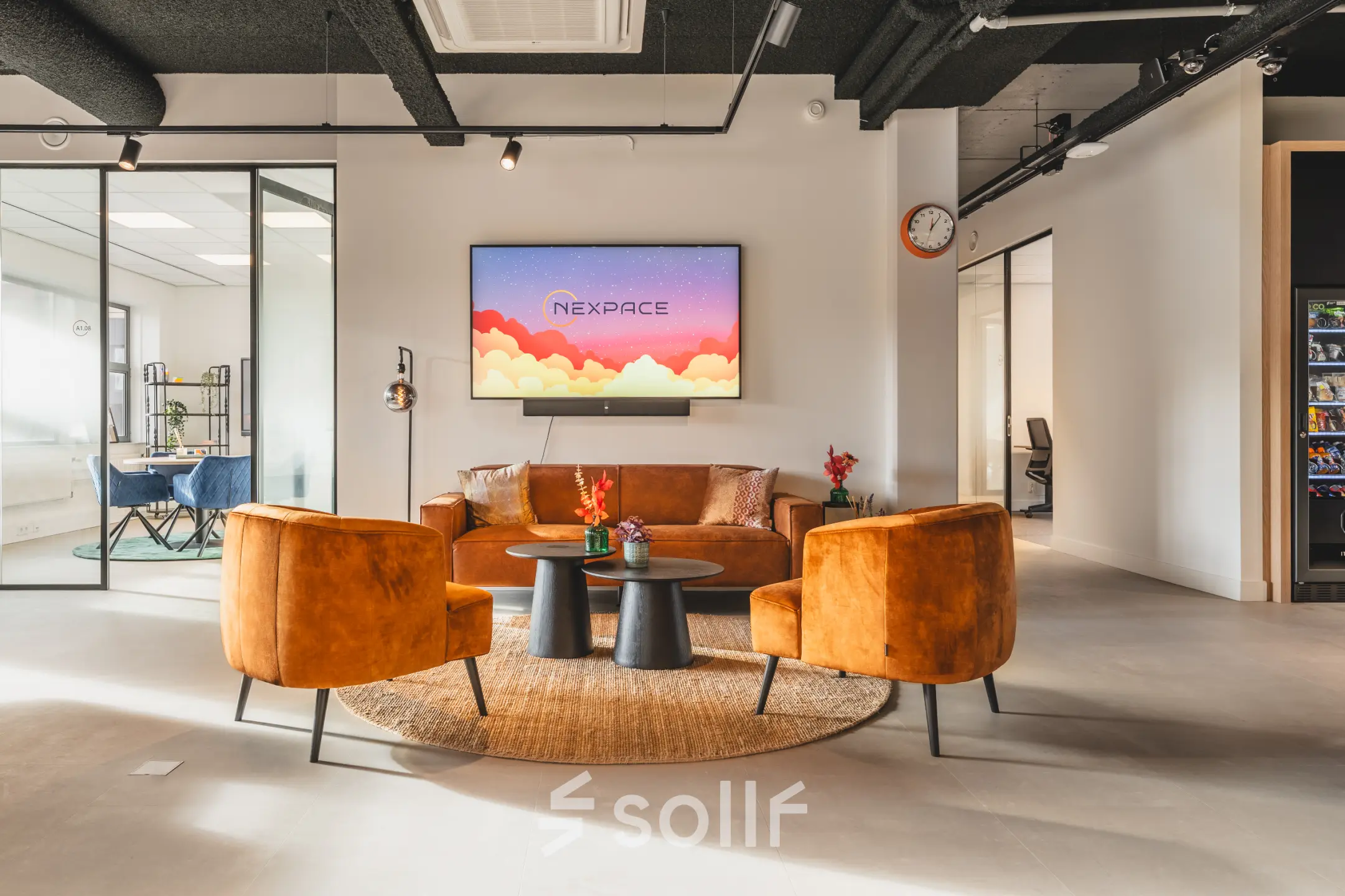 Modern office lounge area at Paasheuvelweg 20, Amsterdam South East with stylish seating, a central coffee table, and a mounted TV. Ideal space for office space rental.