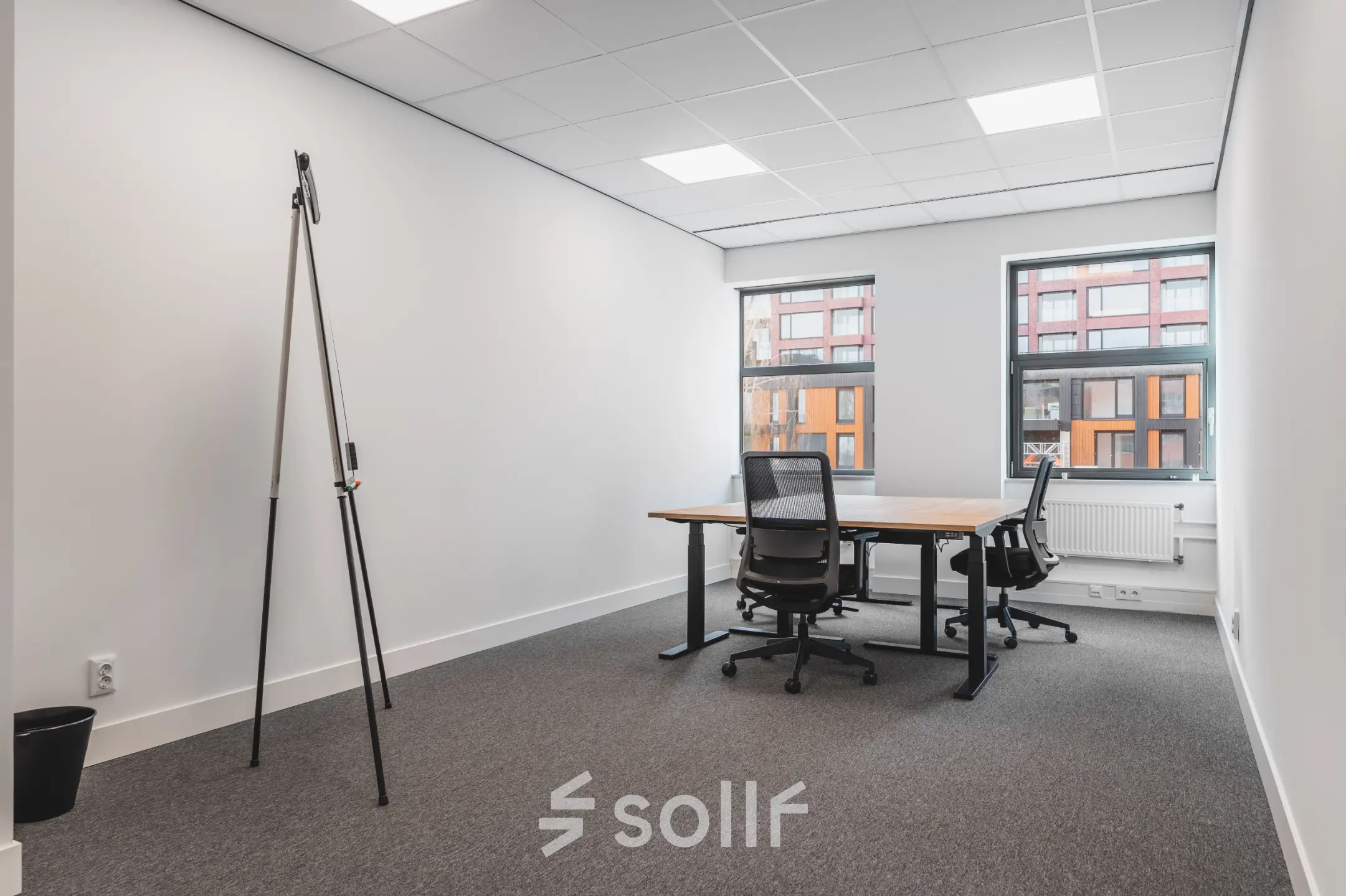 Office space for rent at Paasheuvelweg 20 in Amsterdam South East, featuring two desks and chairs with windows offering natural light.