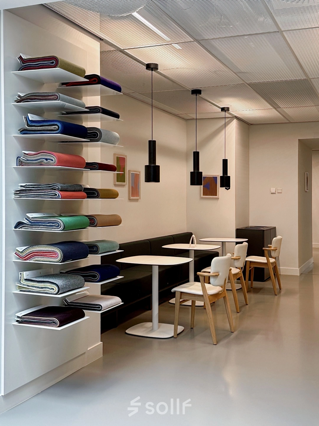 Modern office space in Amsterdam West featuring a furnished seating area with tables and chairs, ideal for office space rental.