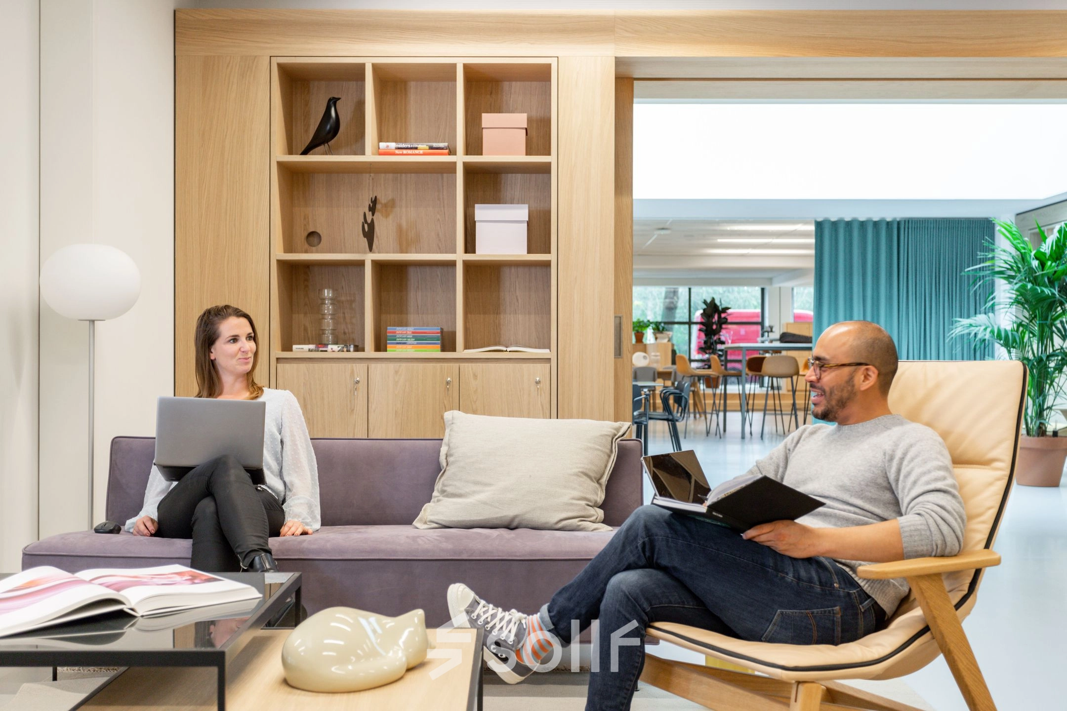 Bright office space at Haarlemmerweg 331 in Amsterdam West featuring a lounge area with people working on laptops and reading. Ideal for office space rental.