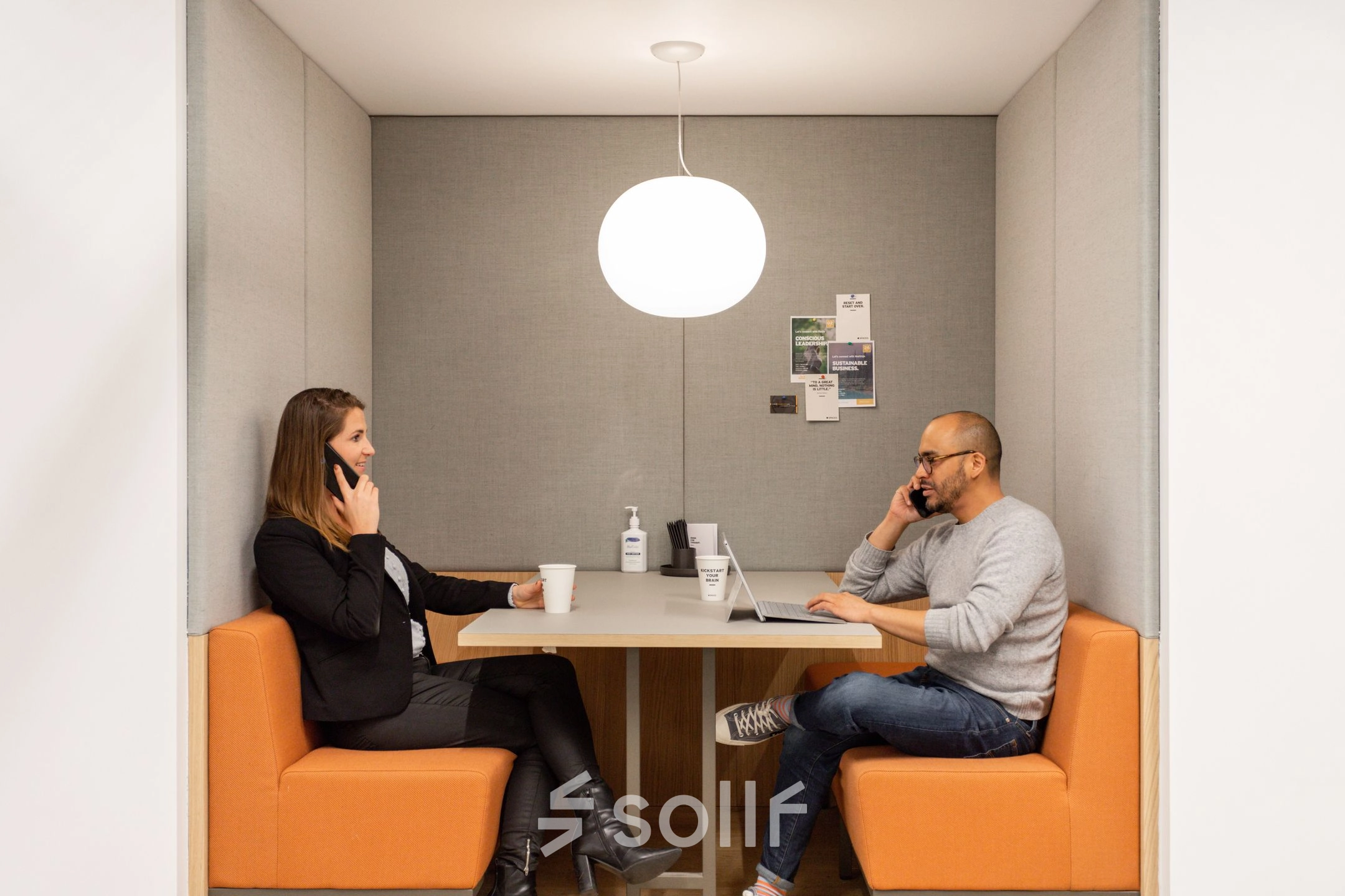 Two professionals engage in discussions within a compact workspace at Haarlemmerweg 331, Amsterdam West, ideal for office space rental.