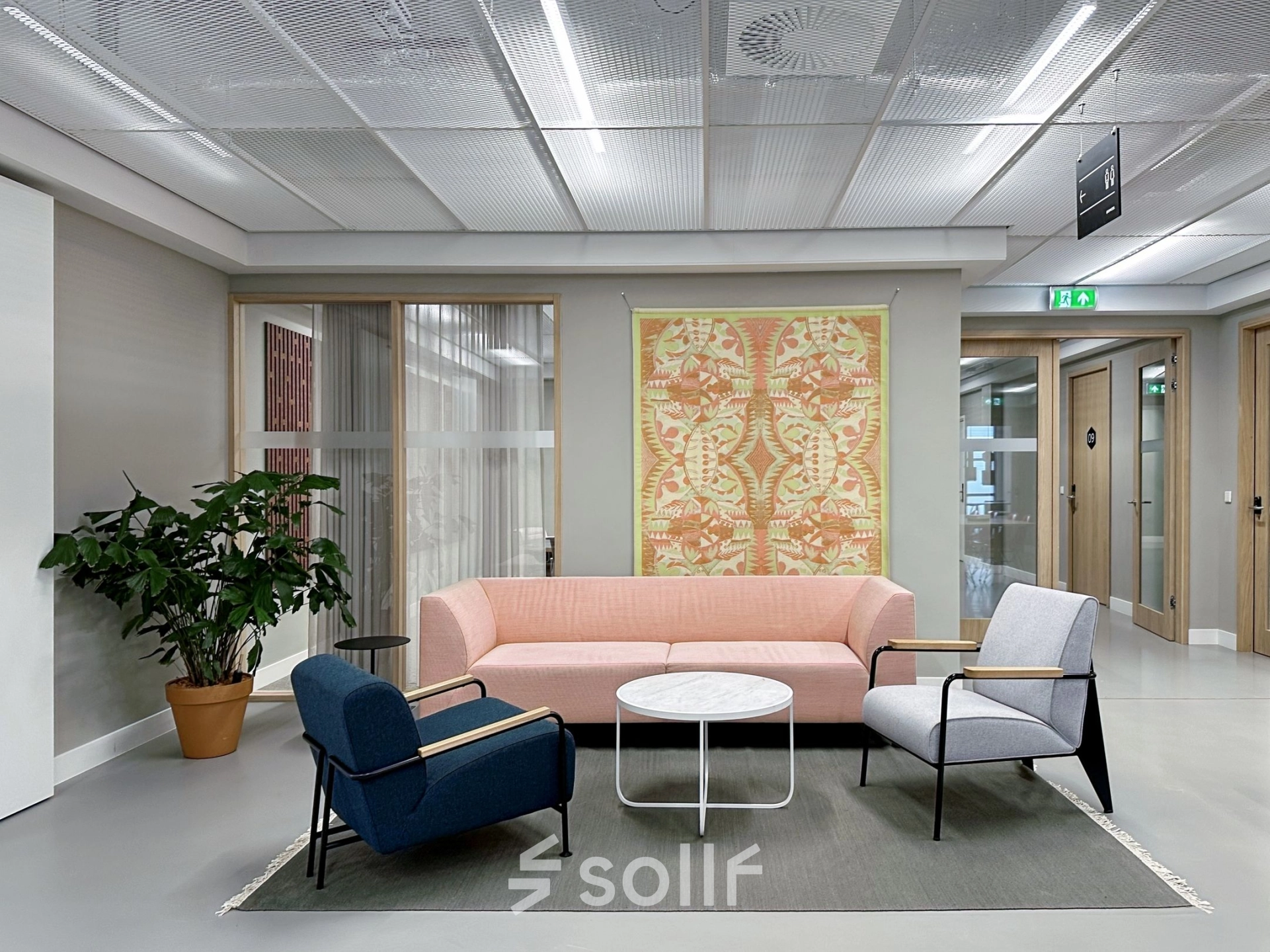 Modern office space for rent at Haarlemmerweg 331, Amsterdam West, featuring stylish furniture and vibrant wall art, ideal for collaborative meetings.